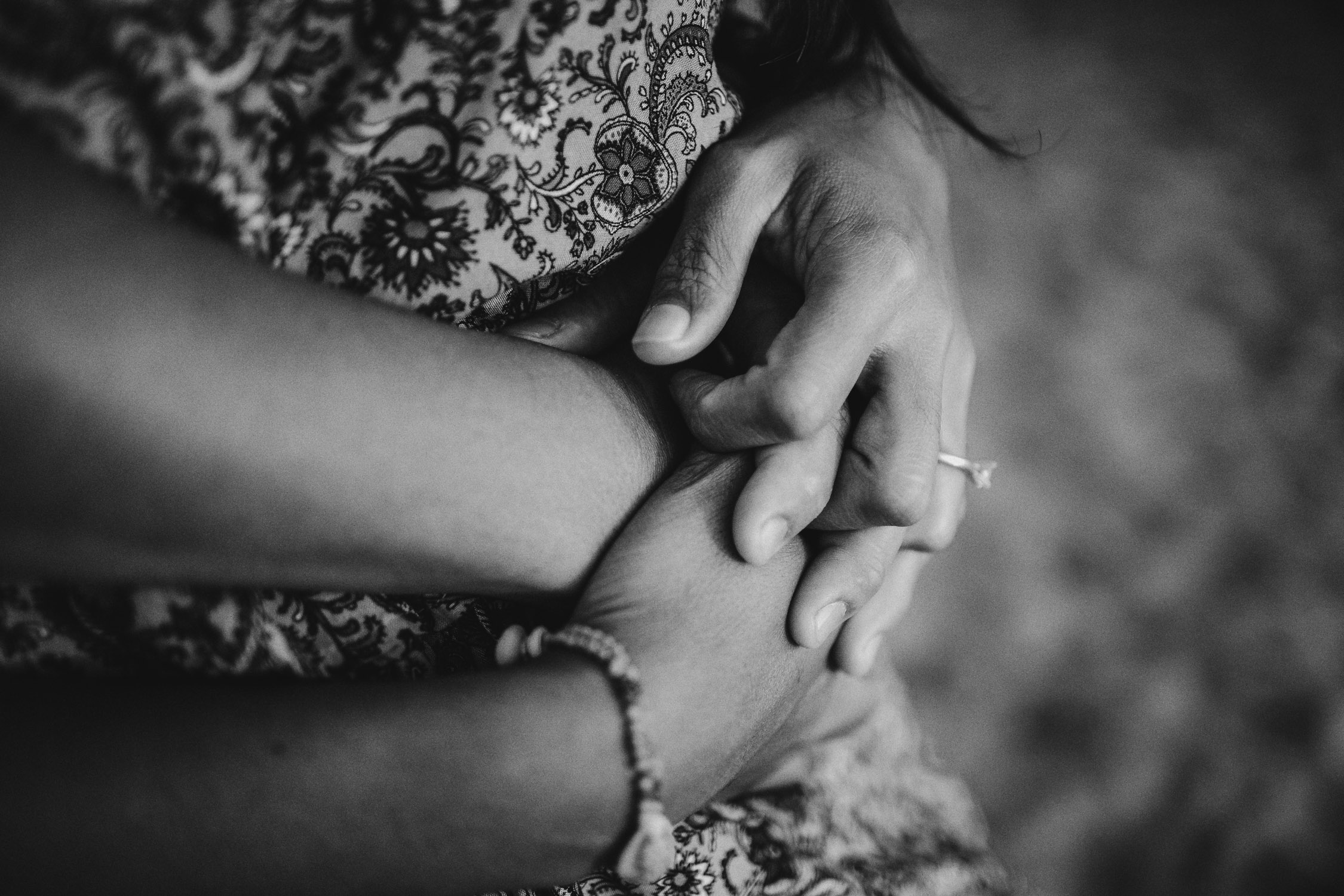 Hands overlapping with engagement ring showing during Kauai engagement photoshoot by Liz Koston. 