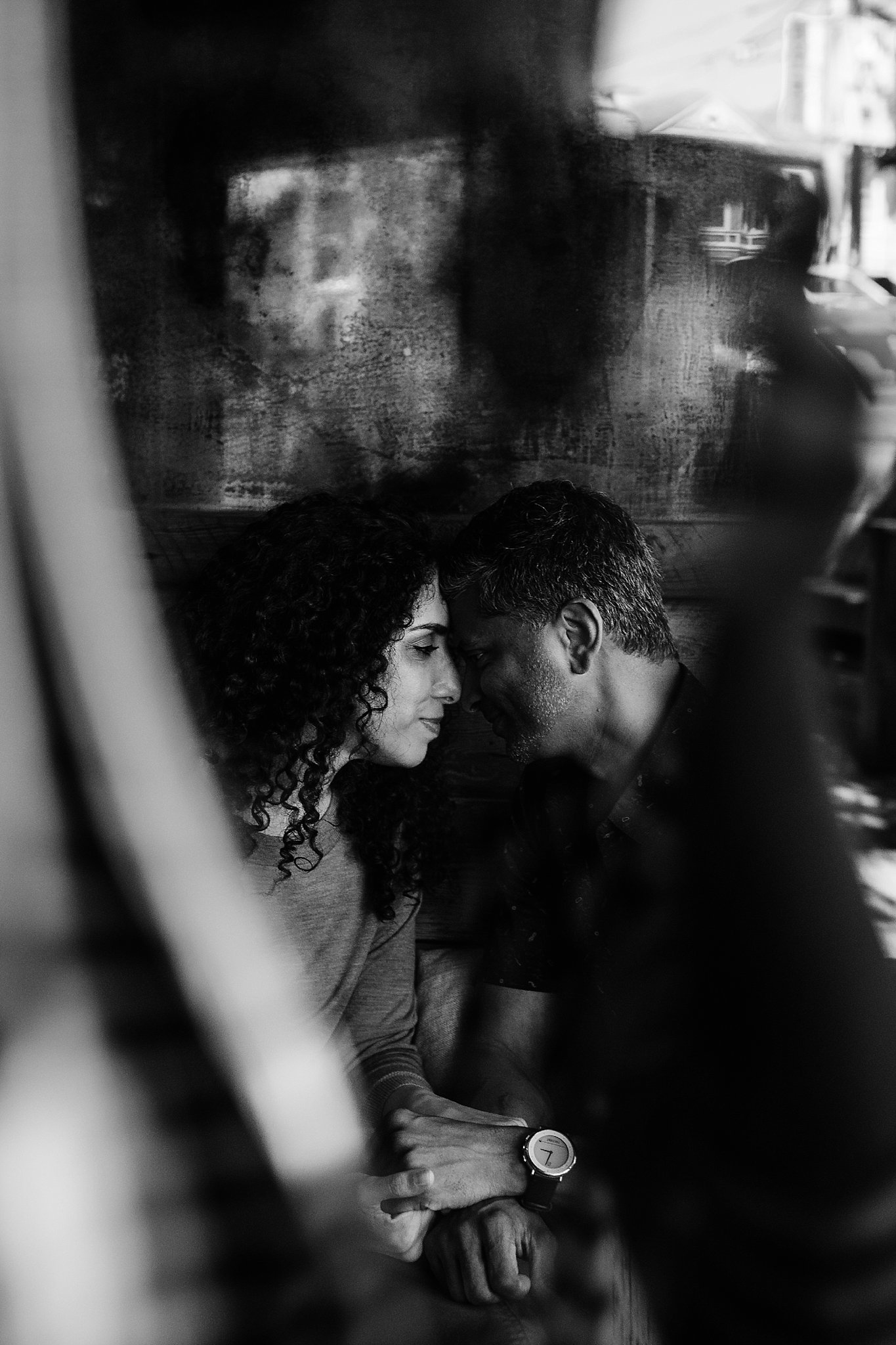 Black and white image of couple with foreheads touching in a store in San Francisco during their engagement photoshoot.