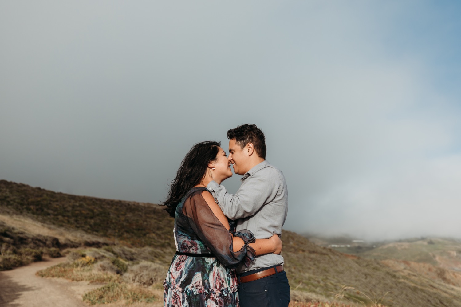 Couple leans in for a kiss during their engagement photoshoot at Rodeo Beach.