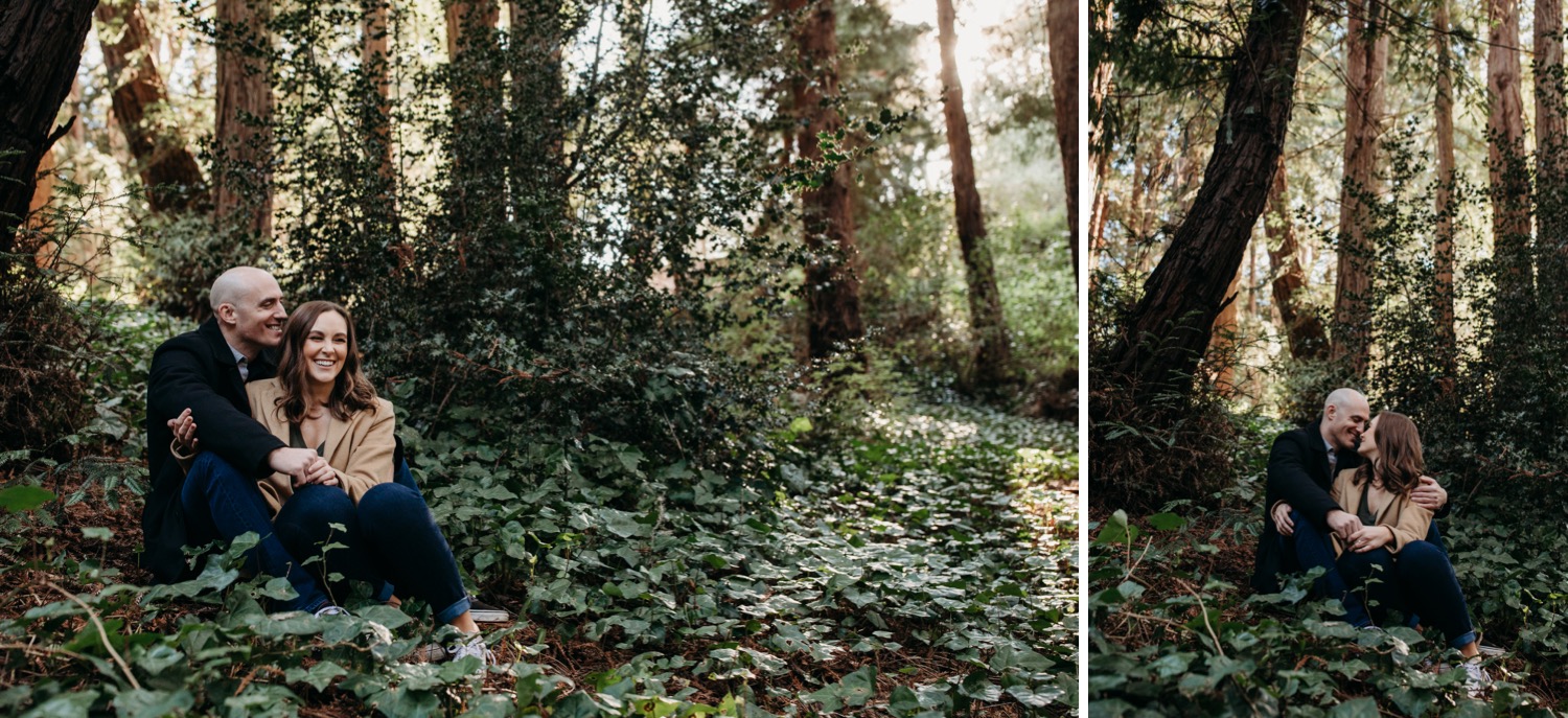 Couple sits in green field surrounded by redwoods on their Golden Gate Park engagement photoshoot.