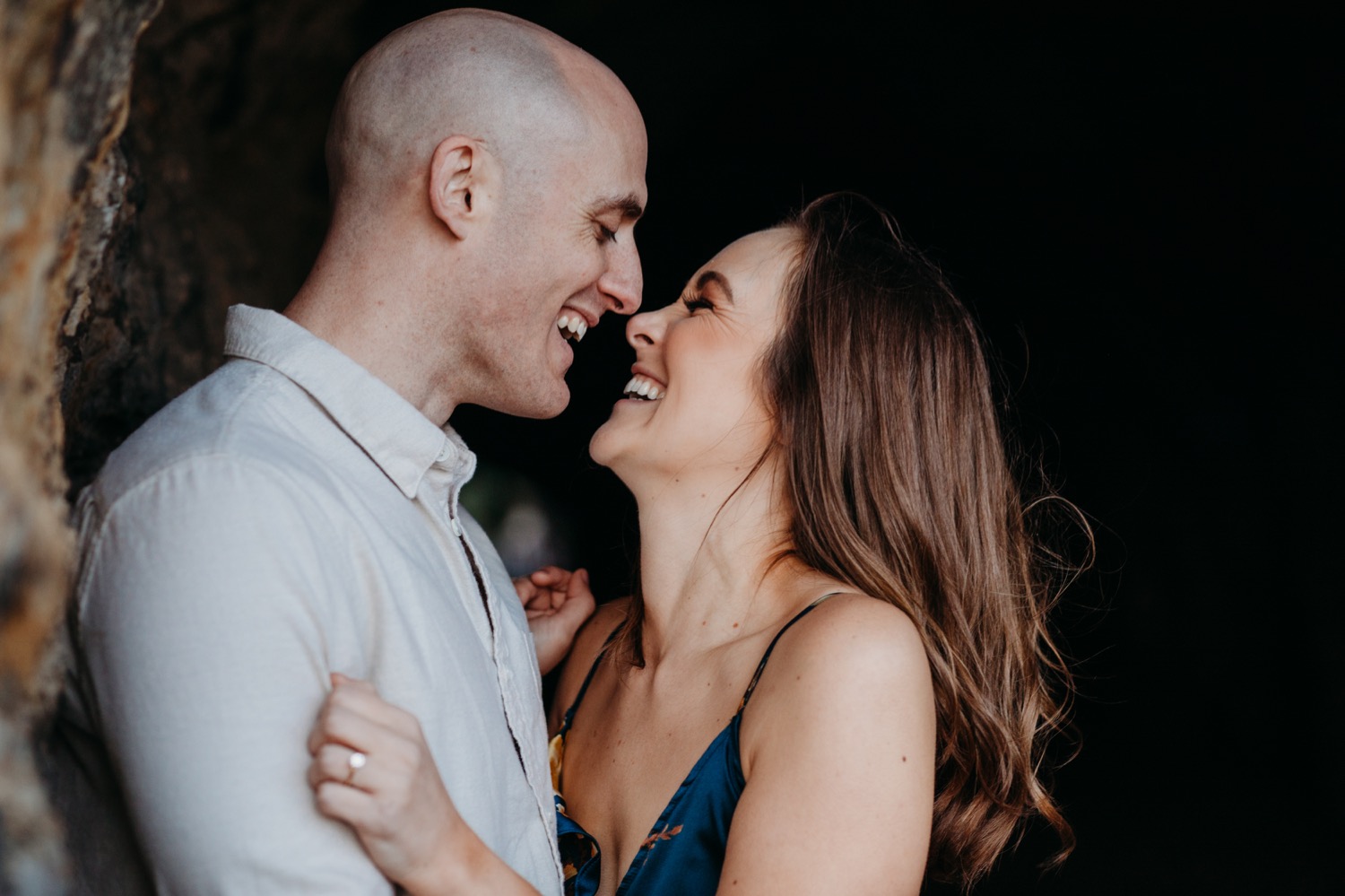 Couple hugs and smiles wide during their Sutro Baths engagement photos.