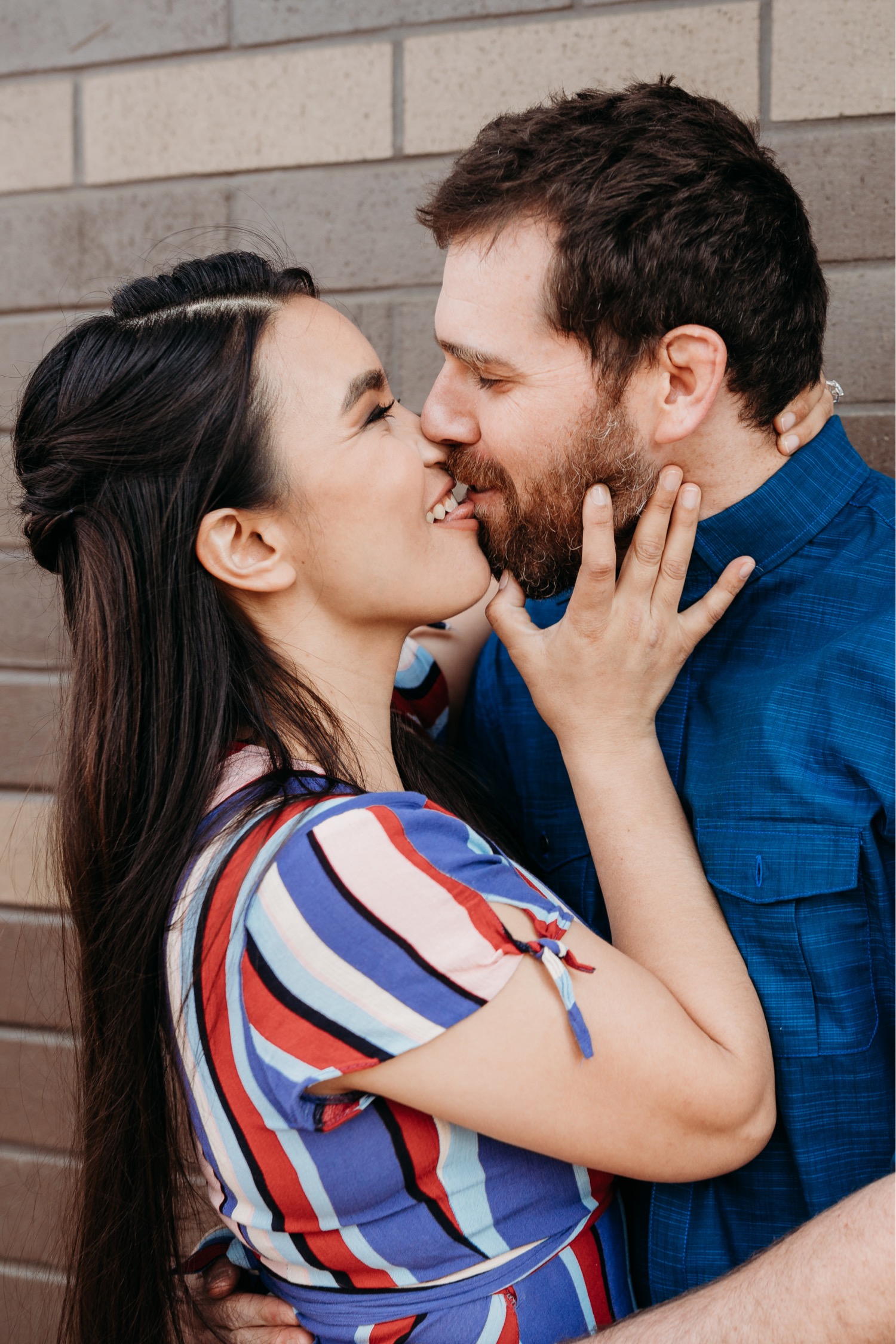 Woman sticks tongue out at fiance as he goes in for a kiss during their engagement photos.