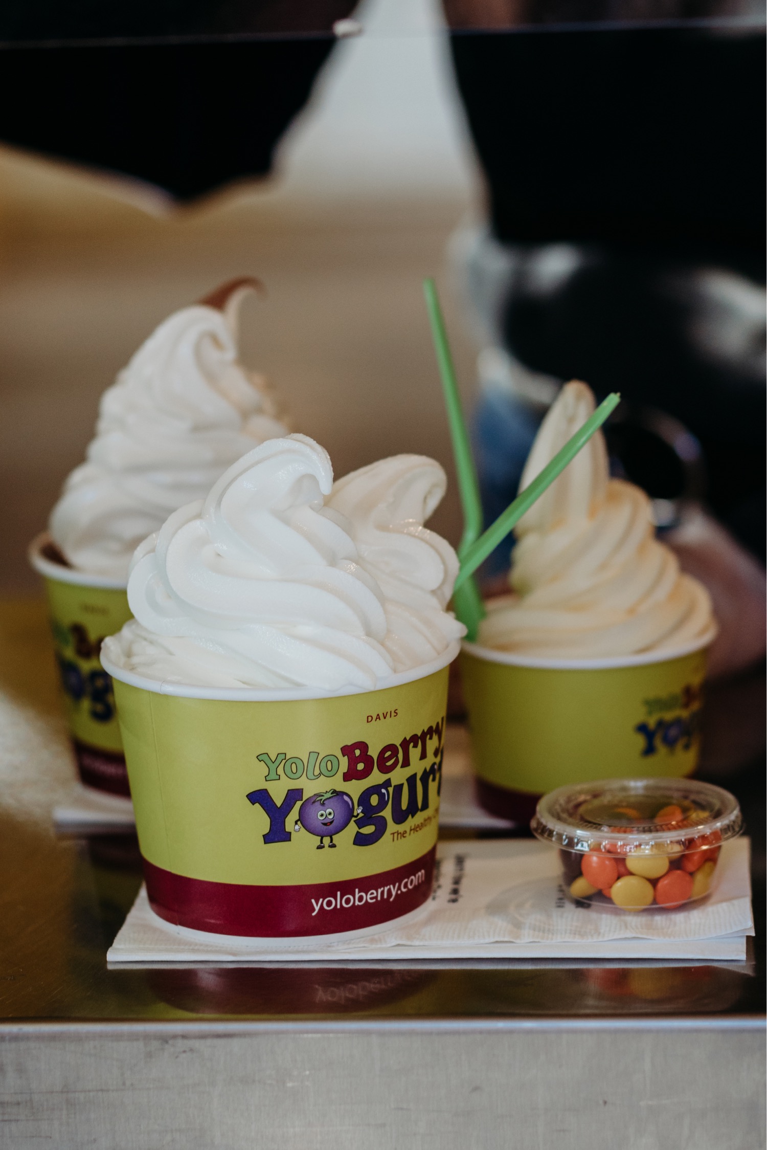 Three frozen yogurt cups on a table.