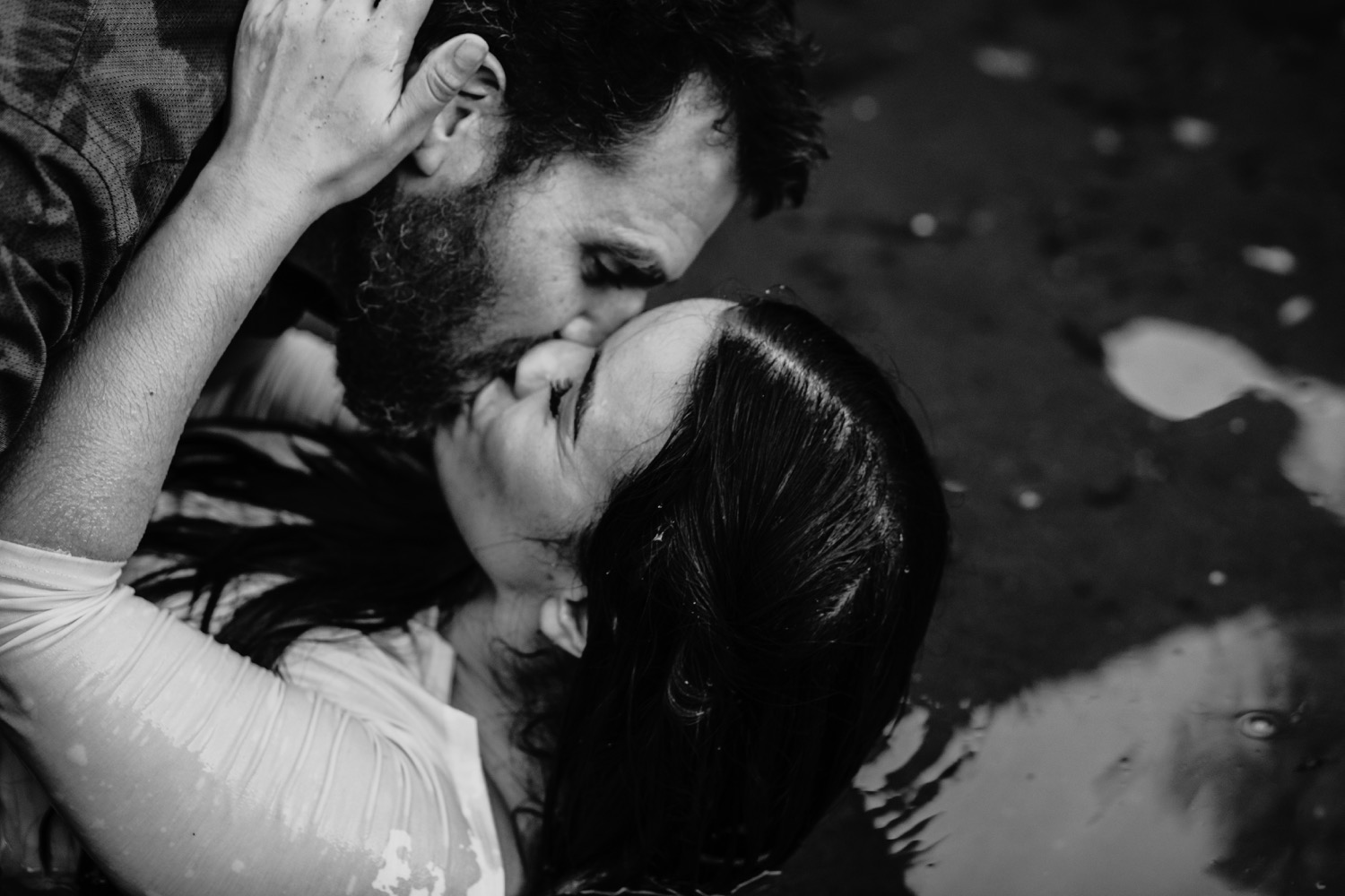 Couple kisses passionately on the river bank during their engagement photos.
