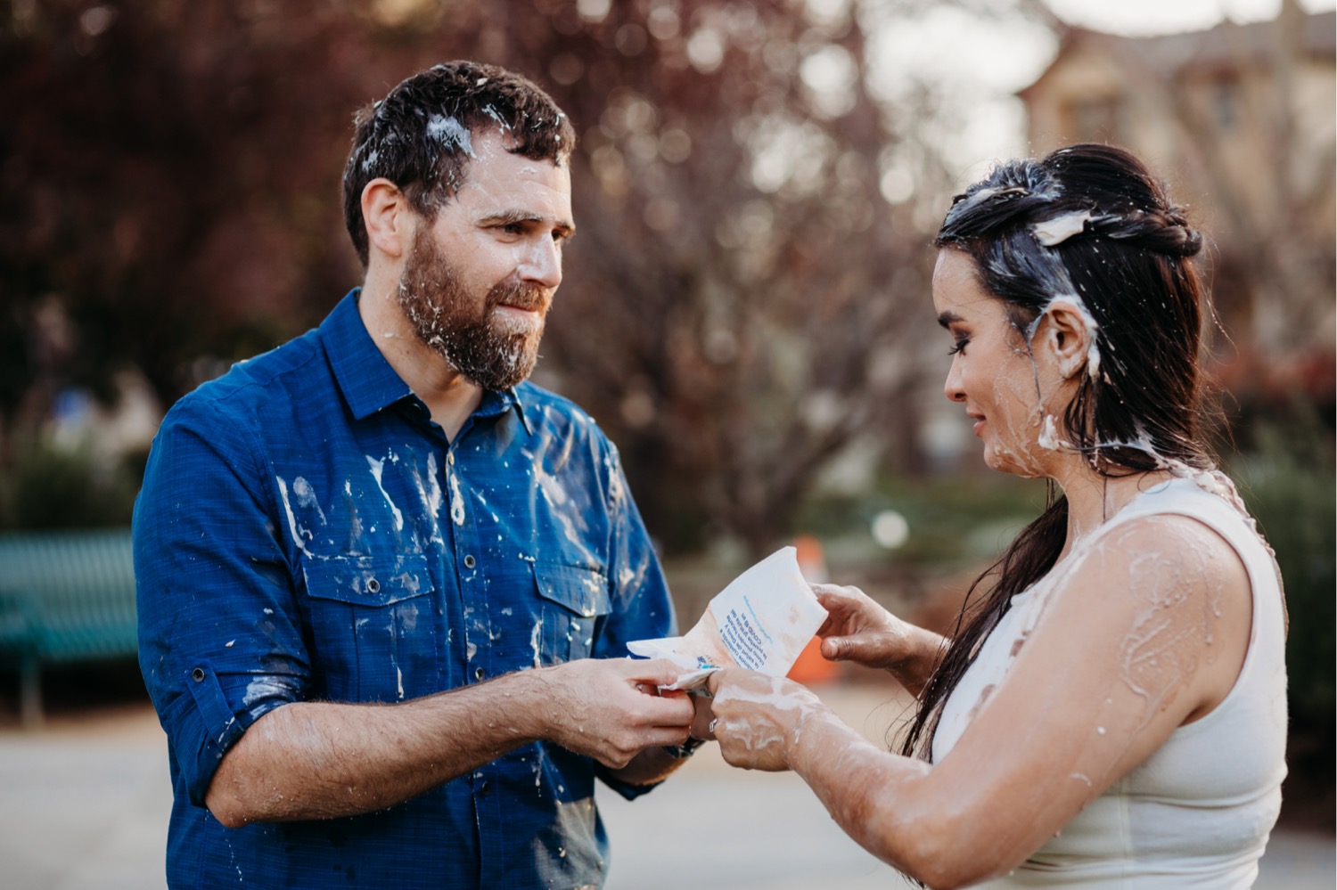 Couple cleans up with napkins after their engagement photo ice cream food fight.
