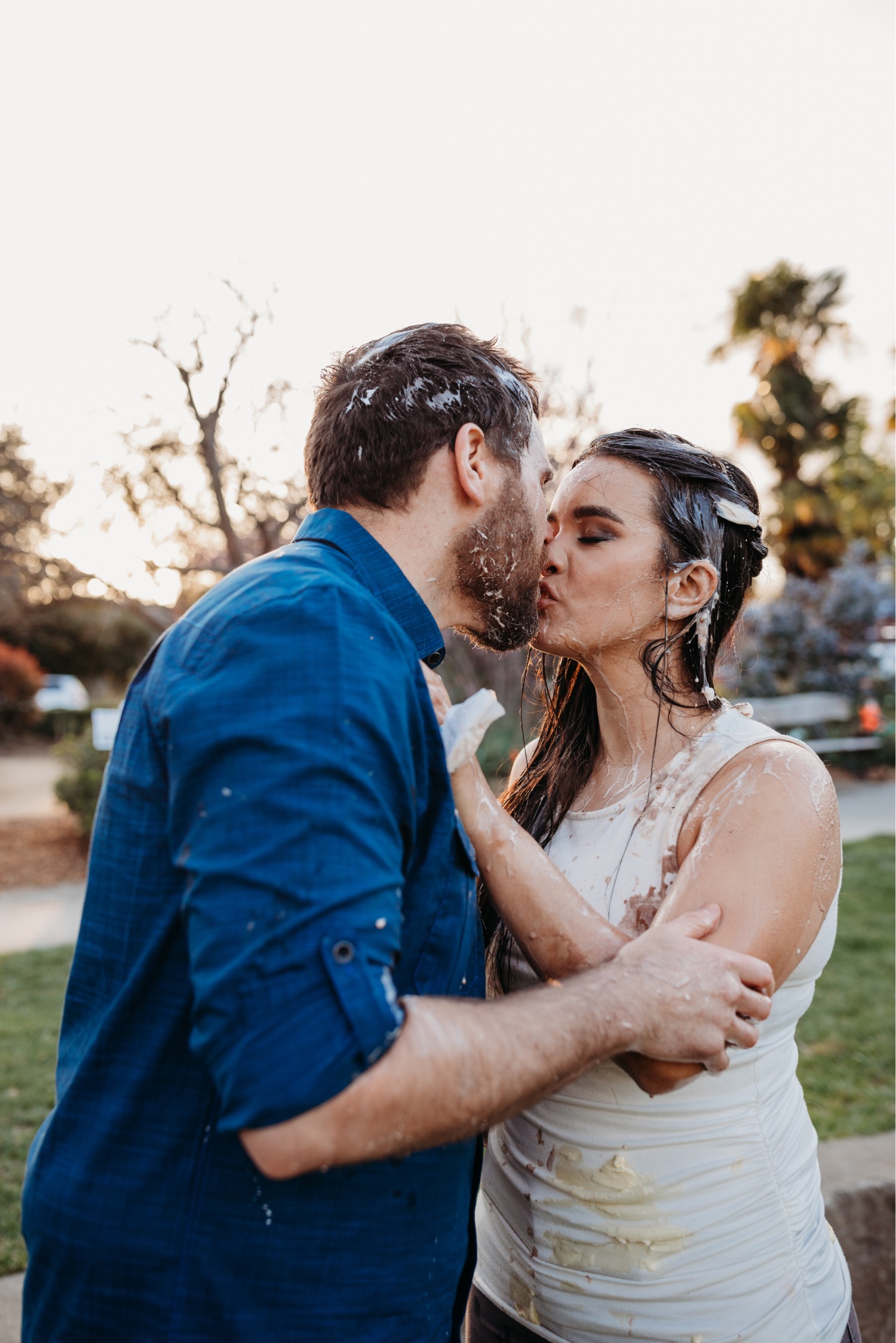 Couple kisses after an engagement photo ice cream food fight.