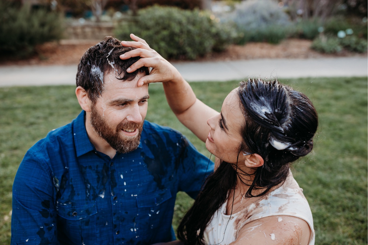 Woman wipes ice cream off of her fiance's forehead after their engagement shoot ice cream fight.