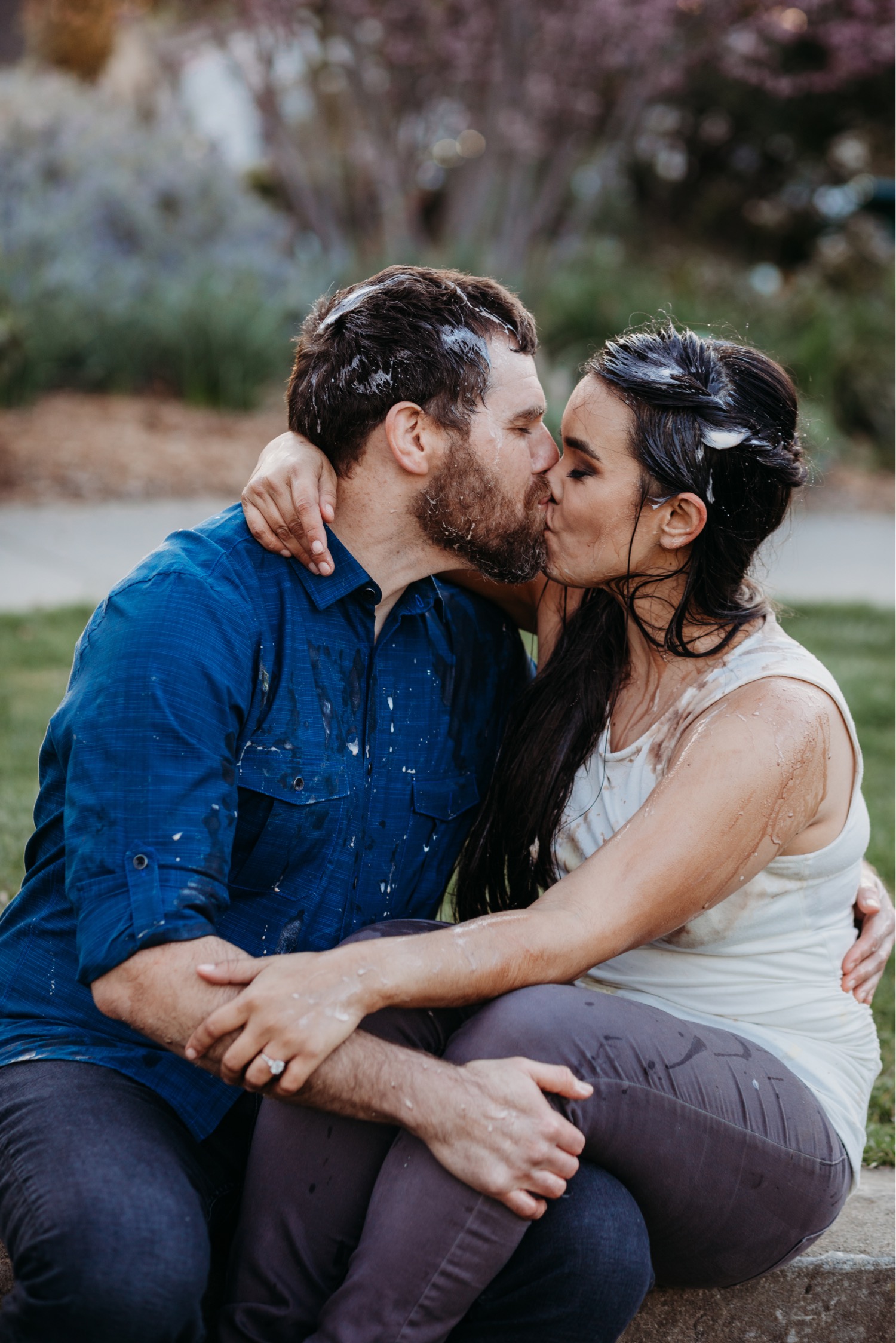 Couple kisses covered in ice cream after their ice cream food fight. 