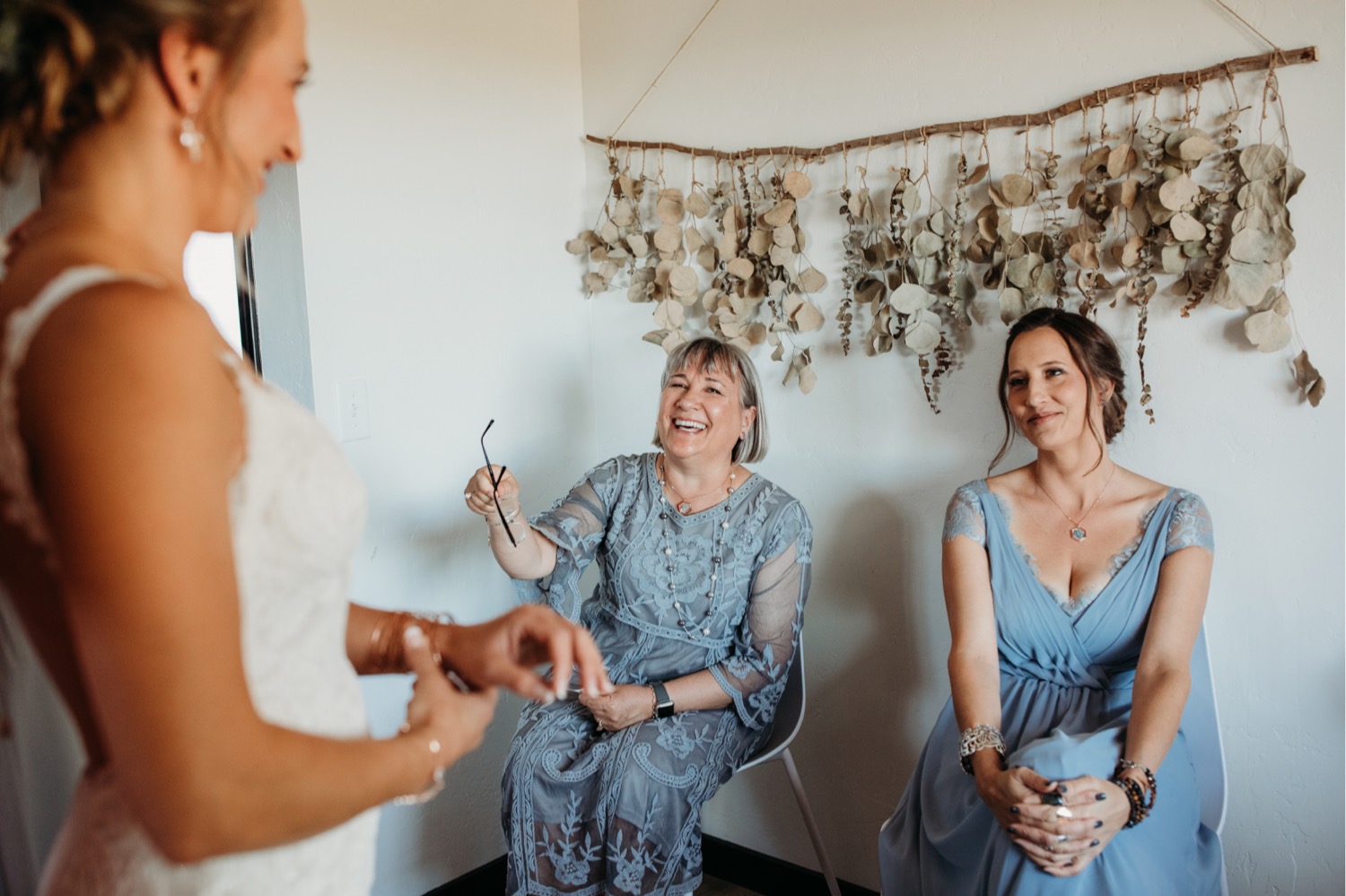 Bride laughs with her mom and bridesmaid before her Paso Robles wedding. Liz Koston Photography.