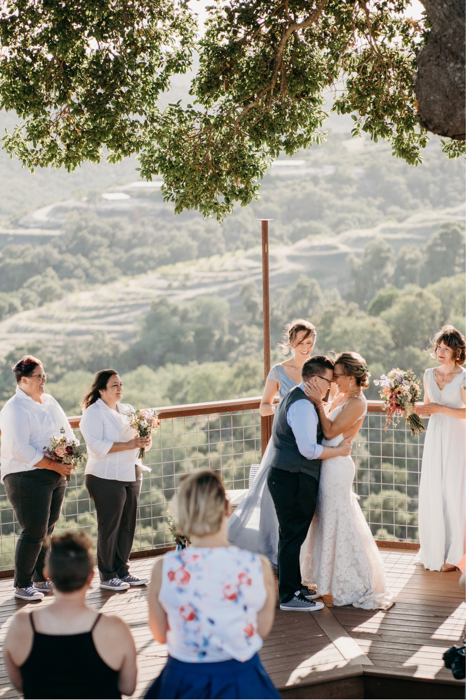Brides embrace under a tree overlooking the Paso Robles winery. Liz Koston Photography.