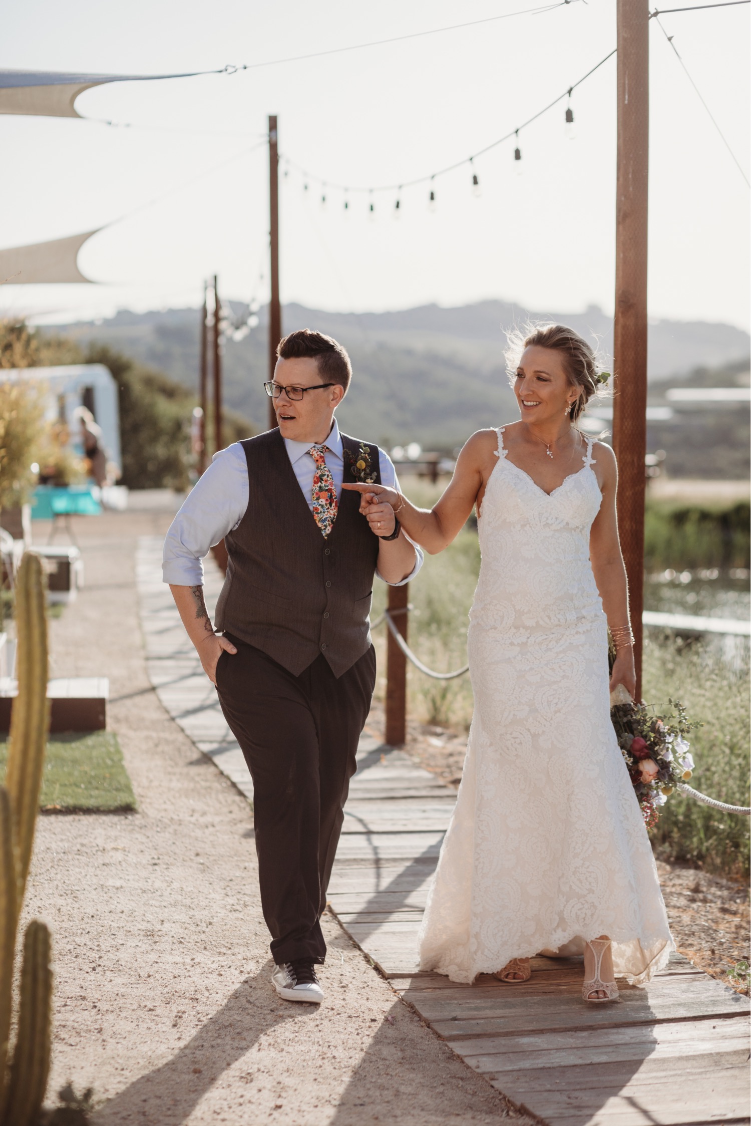 Brides walk holding hands down a path towards their Alta Colina reception. Liz Koston Photography.