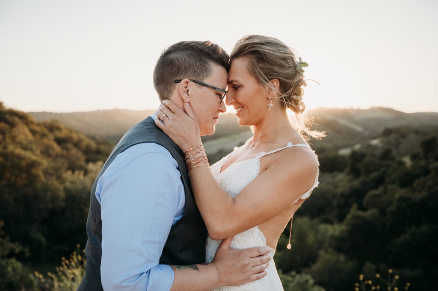 Couple embraces while touching foreheads overlooking the Paso Robles vineyards at sunset. Liz Koston Photography.