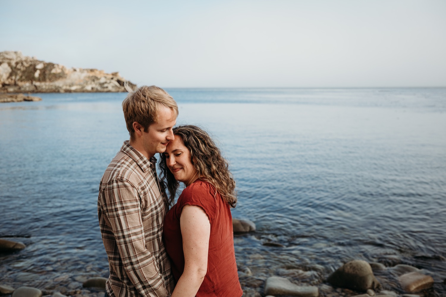 Woman leans into her fiance during their couples engagement photoshoot in Salt Point Park. 