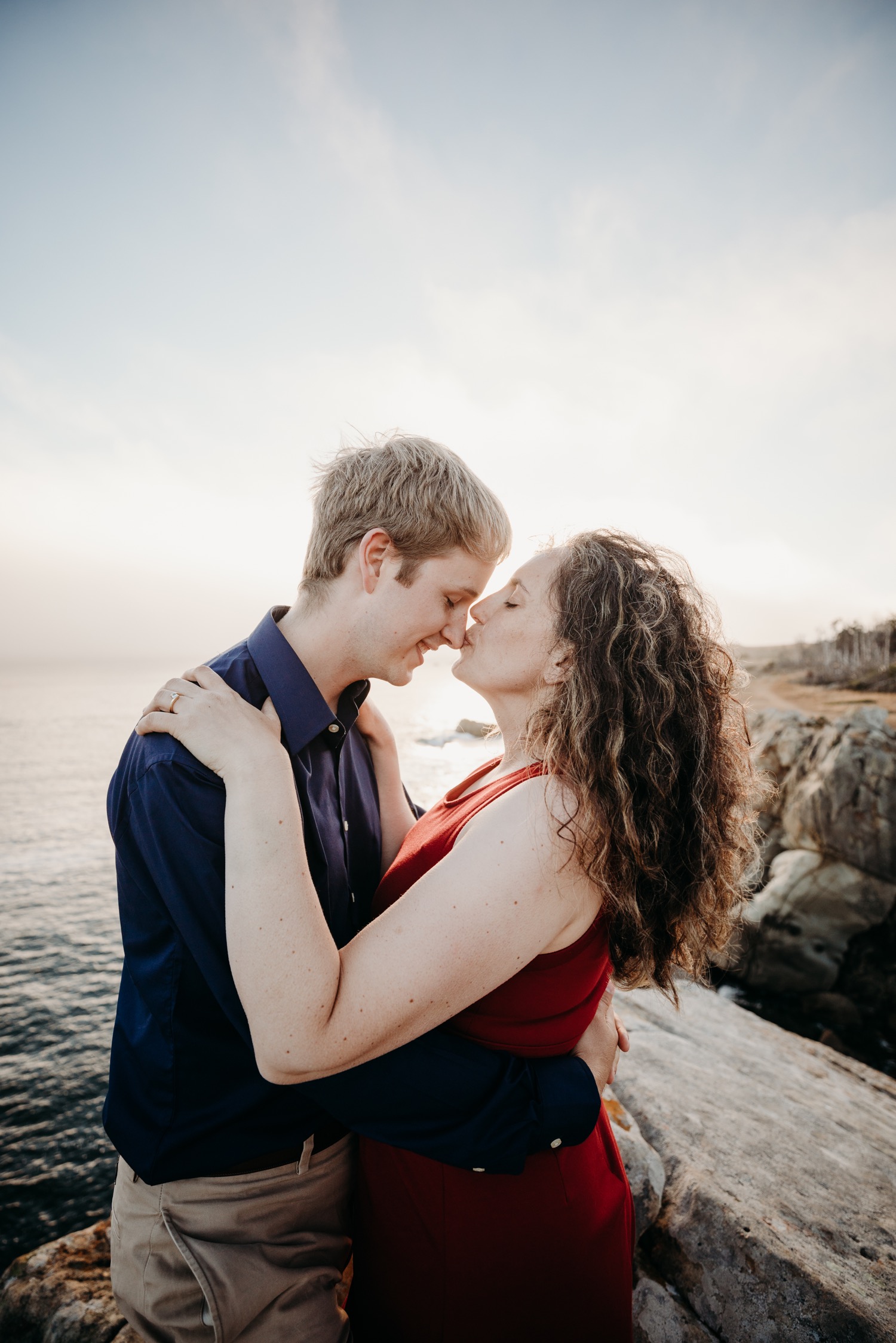 Woman kisses her fiance's nose during their couple's engagement photoshoot in Salt Point Park, CA