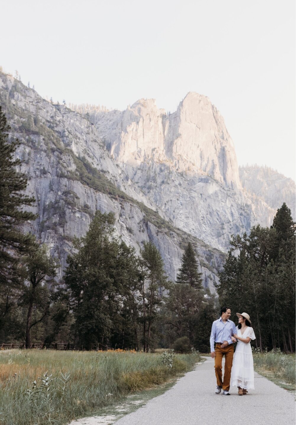 Couple walks arm in arm down a path in Yosemite National Park. Liz Koston Photography.