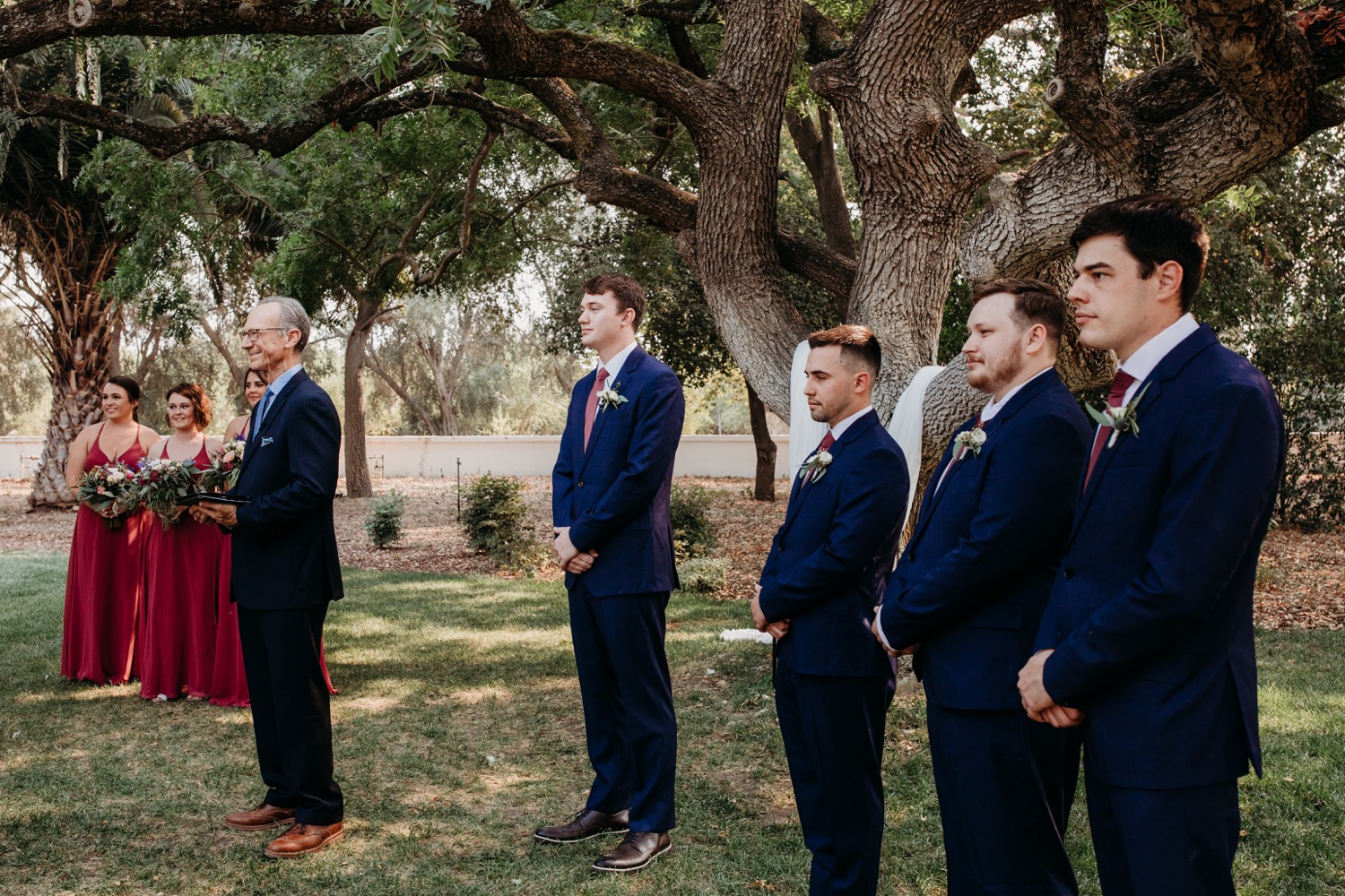 Bridal party and officiant wait for the bride to walk down the aisle at The Maples in Woodland, CA