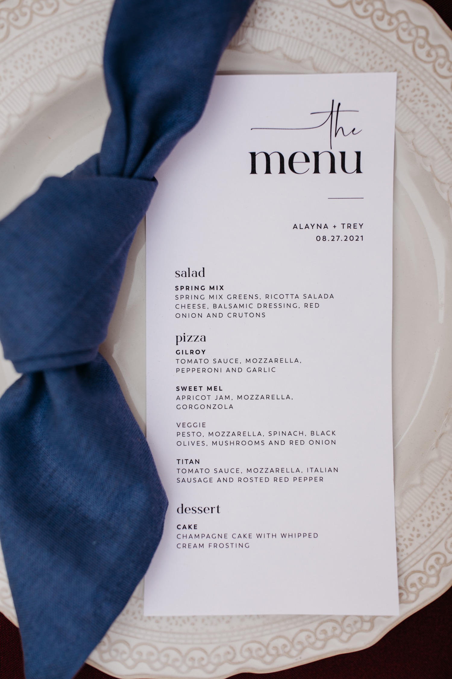 Dinner menu on plate with a blue napkin for Alayna and Trey's wedding at The Maples in Woodland, CA