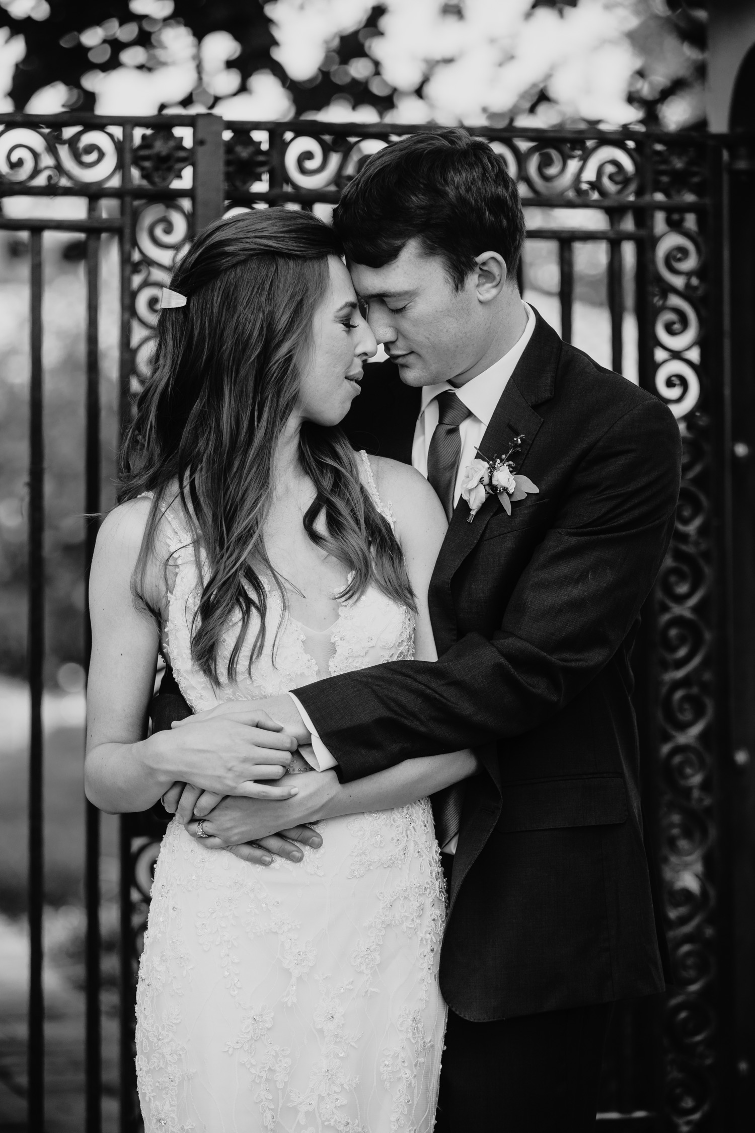 Black and white image of groom hugging bride from the side and their foreheads touching. Alayna and Trey's wedding at The Maples in Woodland, CA.
