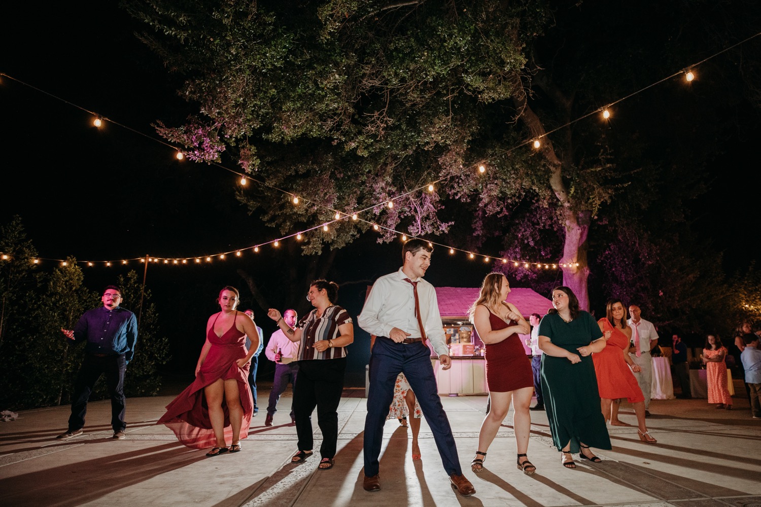 Guests dancing under the lights at Alayna and Trey's wedding at The Maples in Woodland, CA