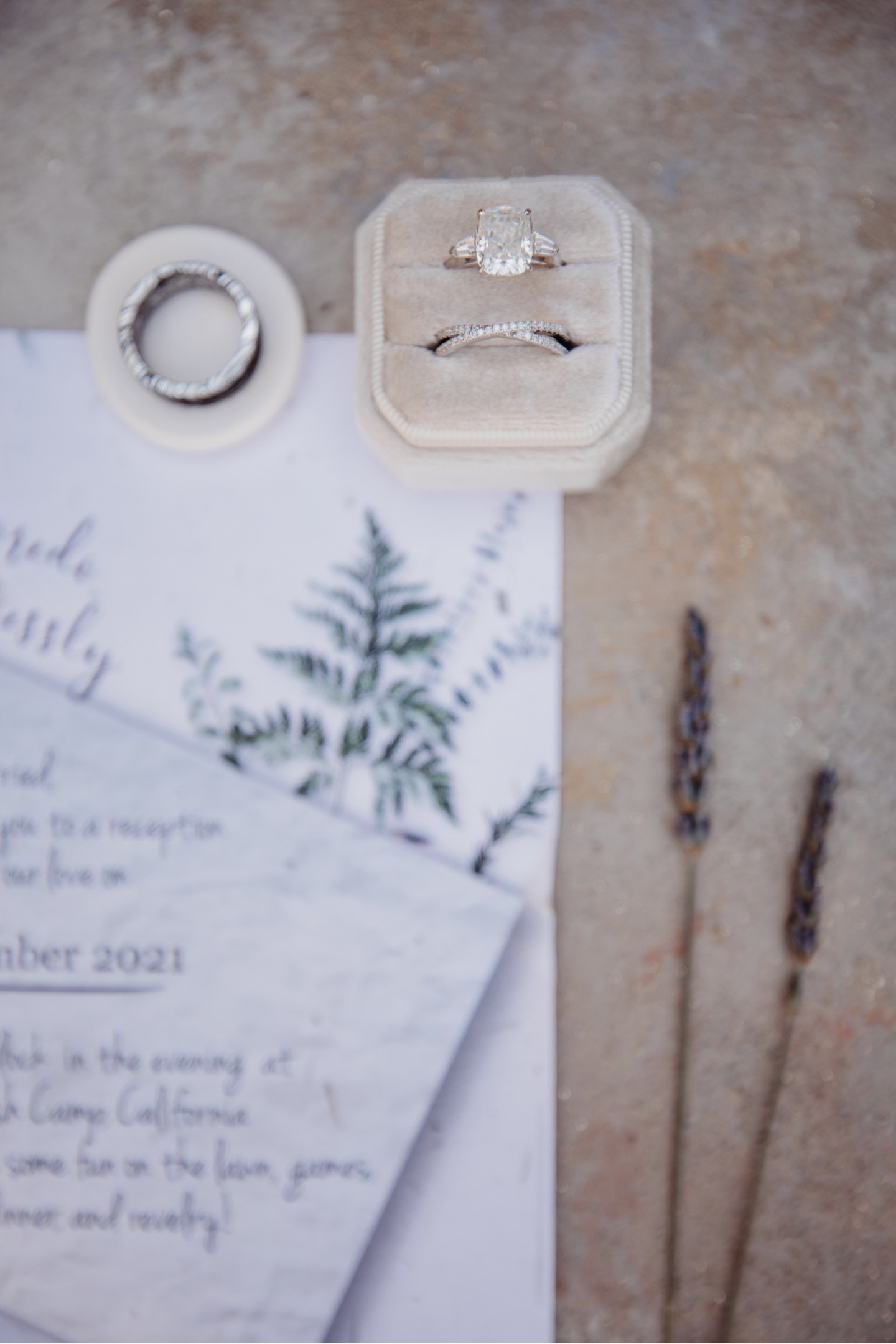 Wedding rings with wedding invitation and two sprigs of lavender