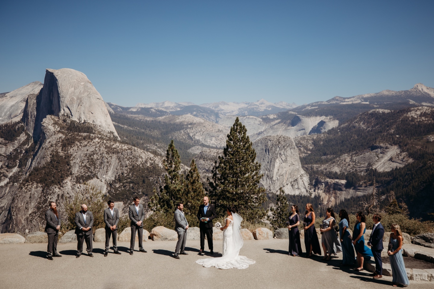 Entire wedding party as the bride and groom get married at Glacier Point in Yosemite National Park
