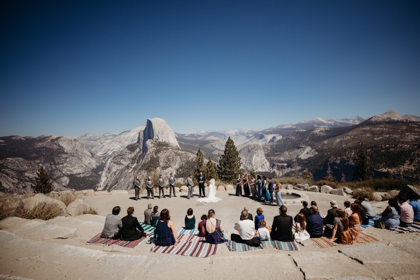 Guests watch bride and groom get married at the Glacier Point amphitheater in Yosemite National Park