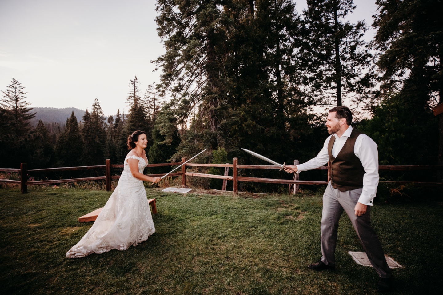 Bride and groom fight with swords during their Yosemite wedding reception at Tenaya Lodge