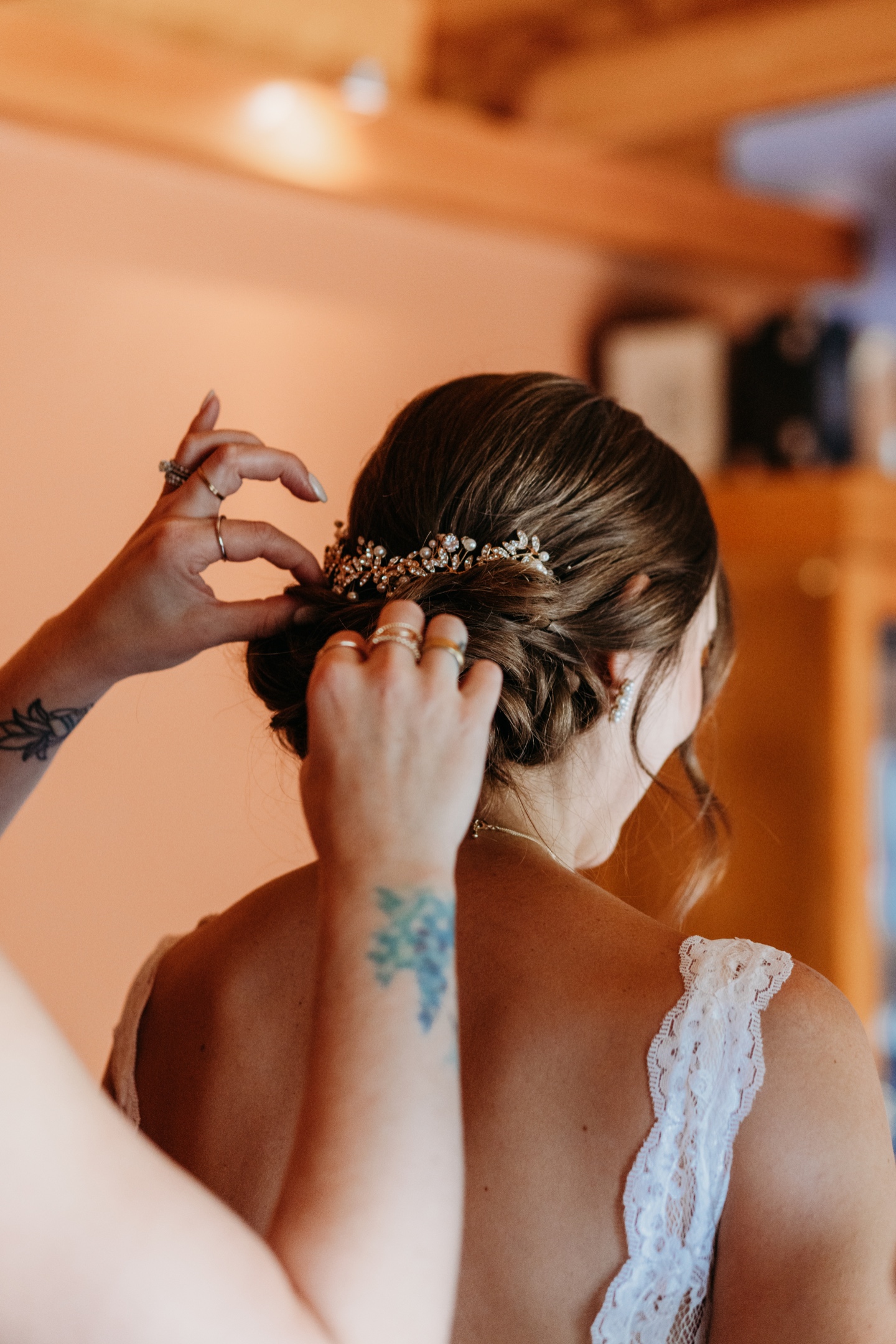 A bridesmaid adds a small pearl barrette to the brides hair. Sacramento wedding photography by Liz Koston.
