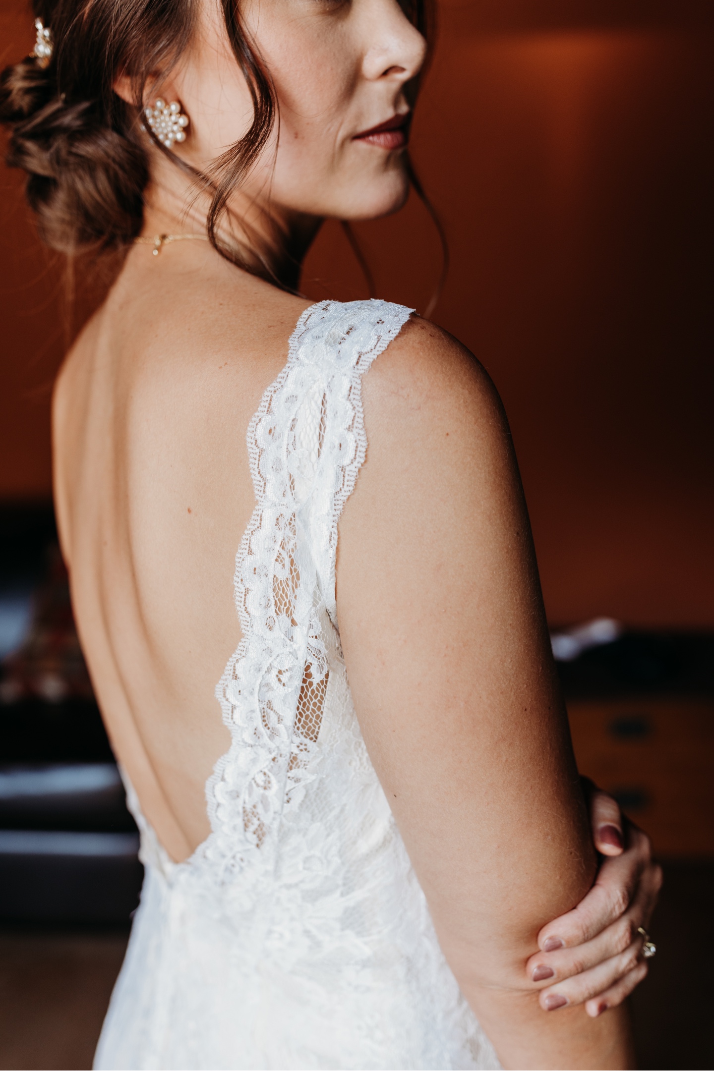 Close up of the bride looking over her shoulder in her white lace wedding dress. Sacramento wedding photography by Liz Koston.