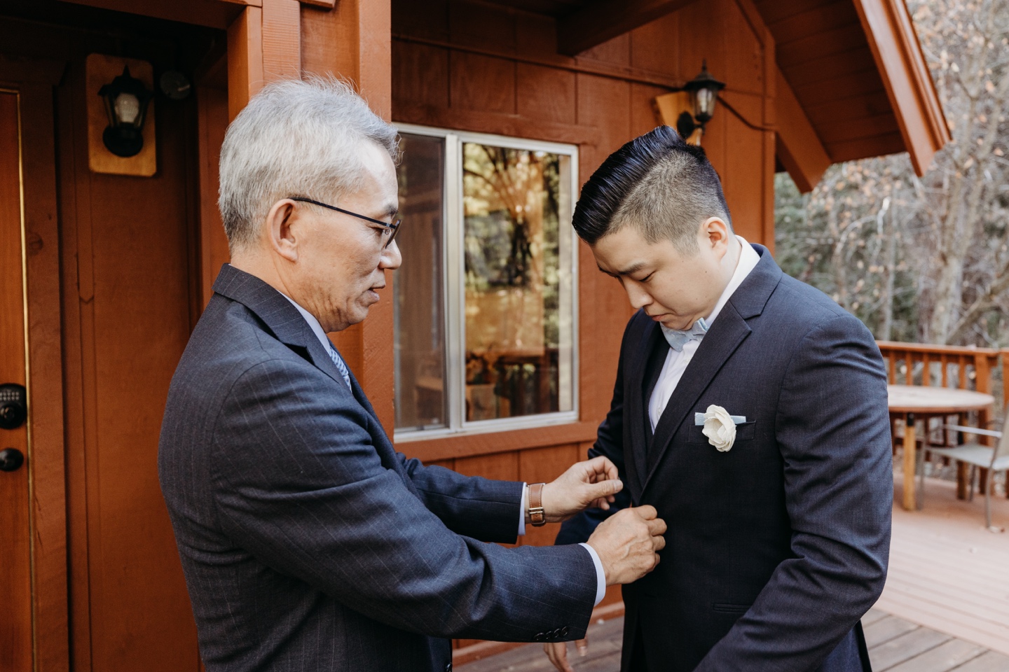 Father helps his son get into his suit jacket before his Yosemite National Park elopement. 