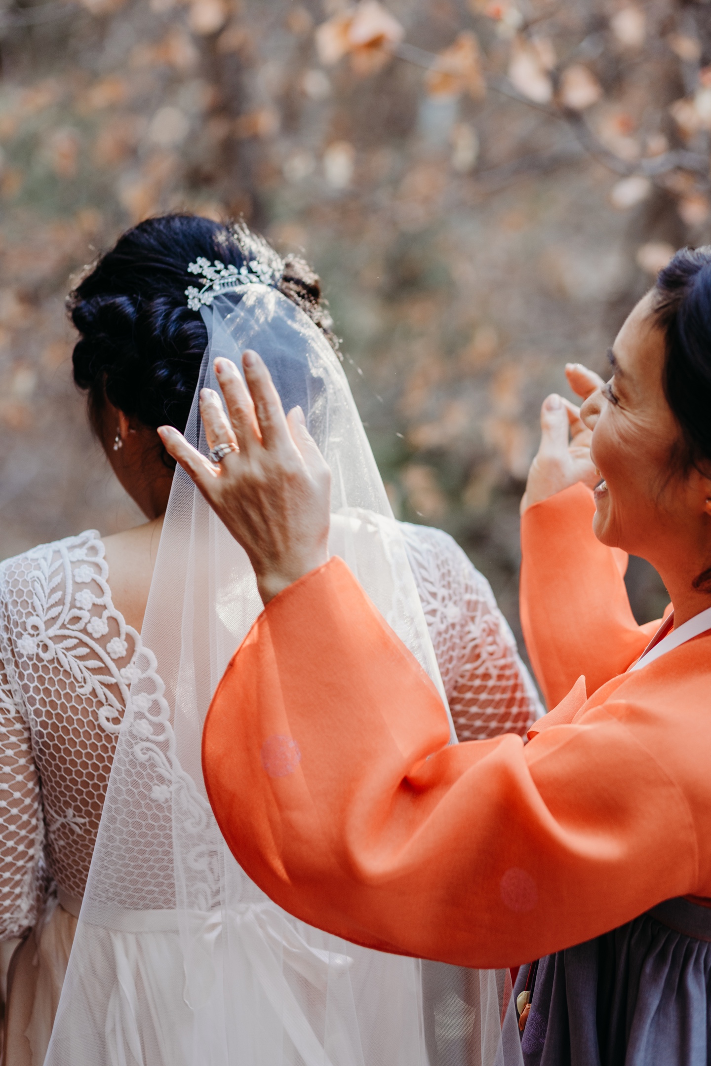 Mother of the Bride smiles widely as she fluffs her daughter's bridal veil as they get ready for her Yosemite elopement. 