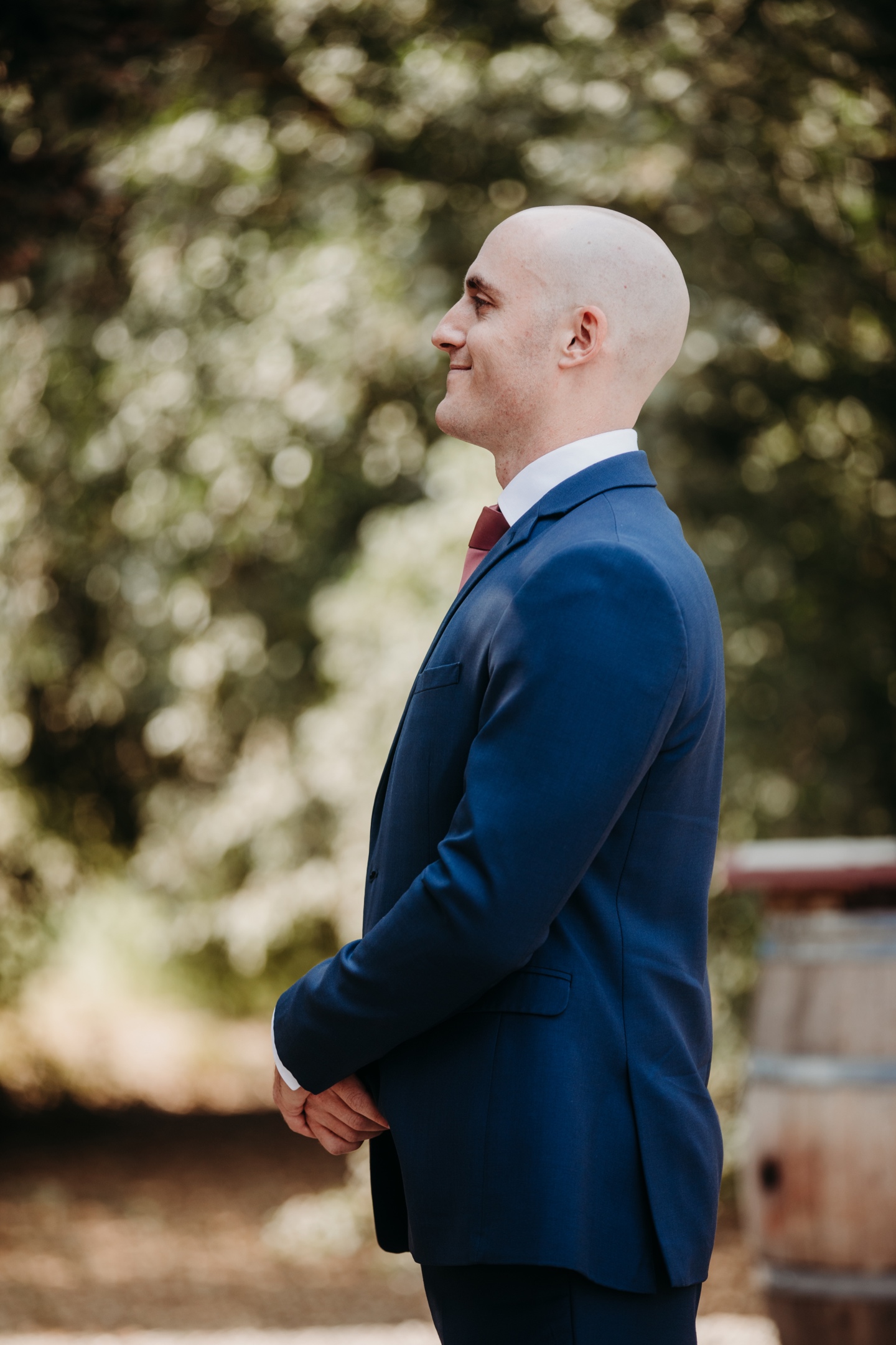 Side profile image of groom smiling in his blue suit.  Photo by Sacramento wedding photographer Liz Koston.