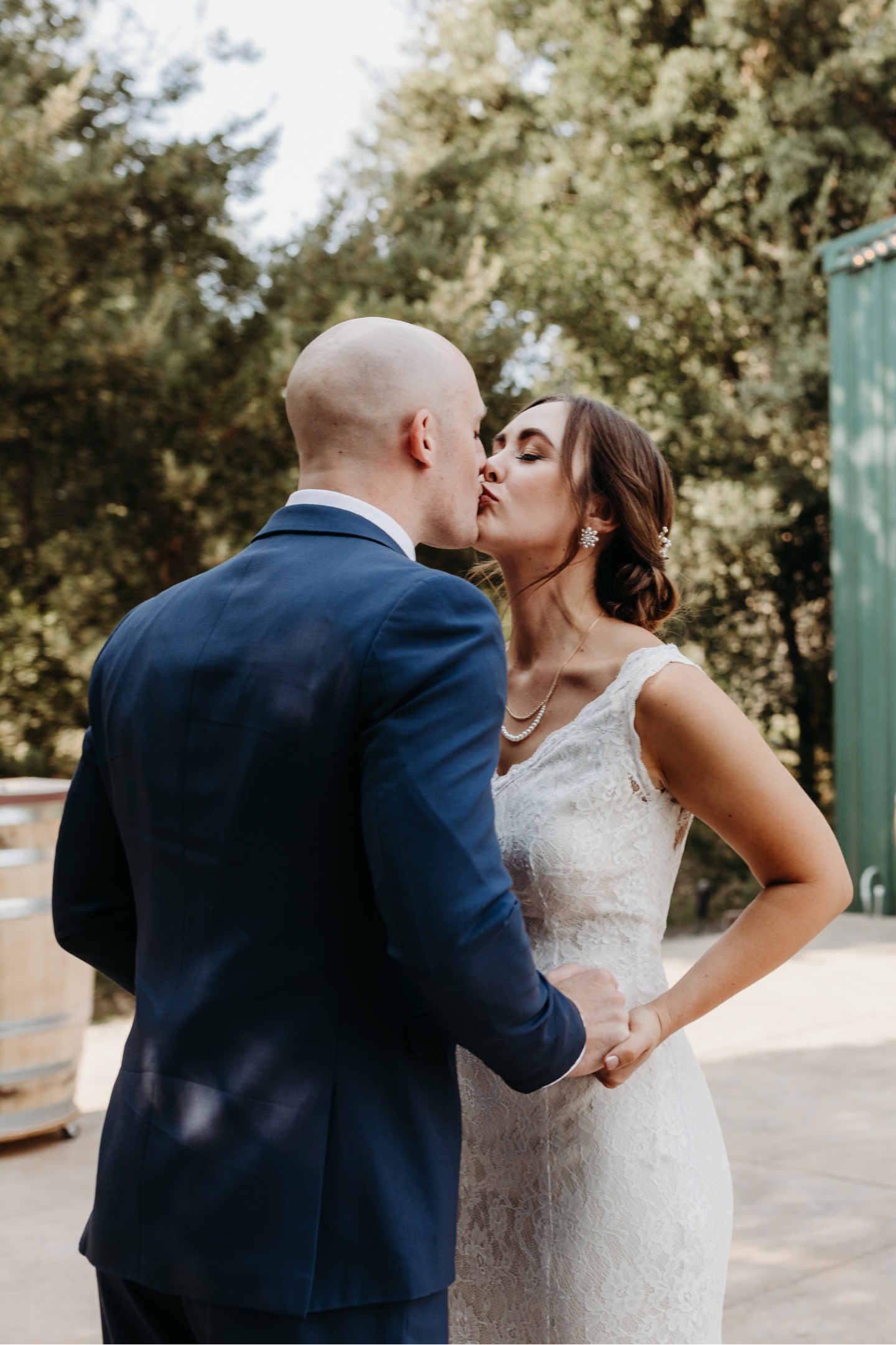Bride and groom kiss during their first look at Juliette winery in Sacramento, California.