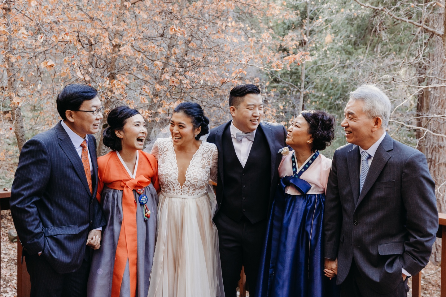 The entire family with the bride and groom laugh together before their Yosemite wedding.
