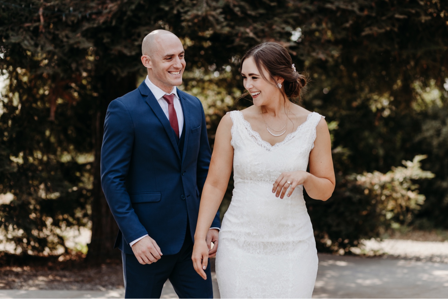 Bride and groom walks up beside his bride as they smile and laugh before their wedding. Wedding photography in Sacramento by Liz Koston.