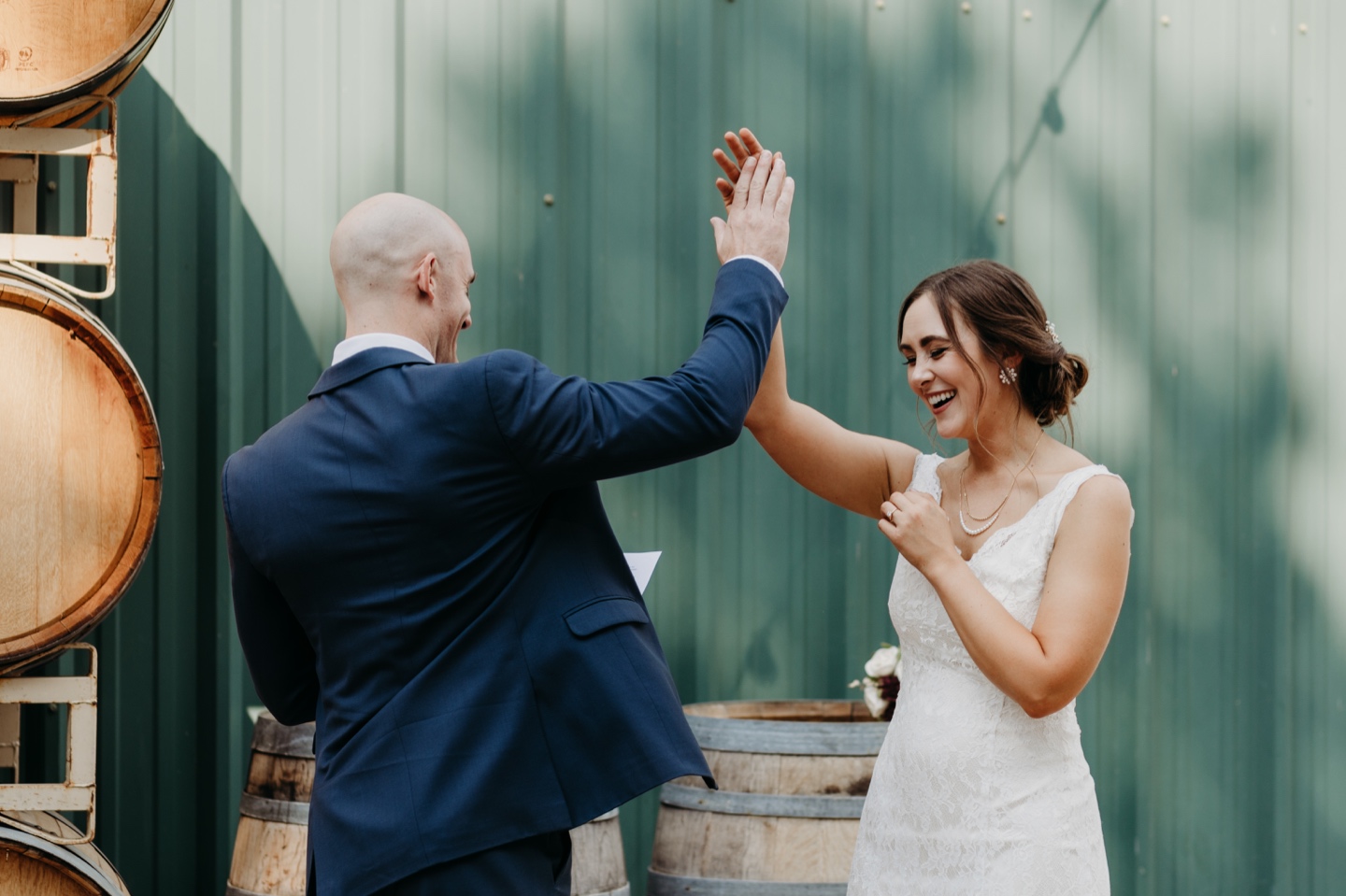 Bride and groom high five after reading their wedding letters to each other. Wedding photography in Sacramento by Liz Koston.