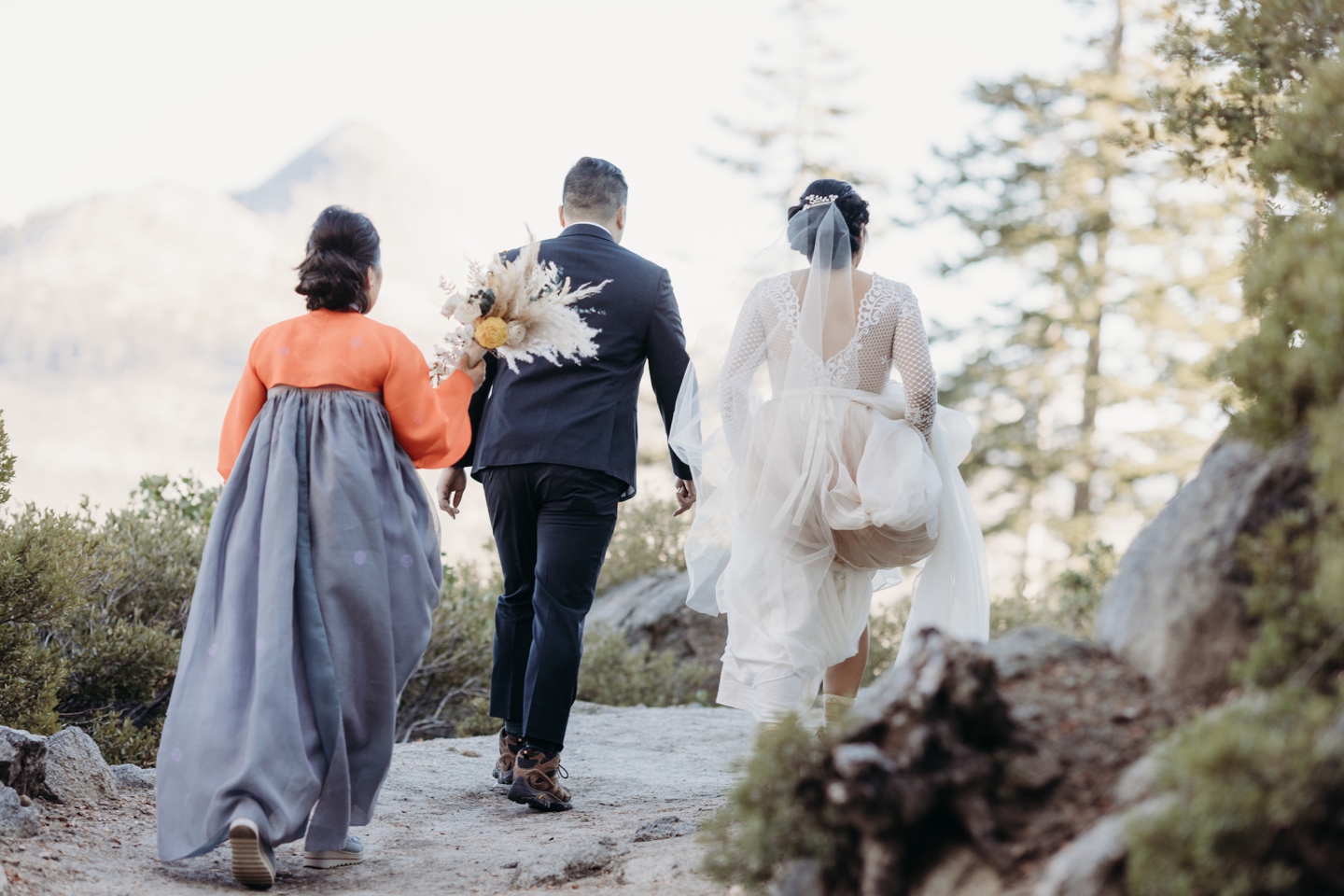 Mother, bride, and groom hike to their elopement location in Yosemite National Park.
