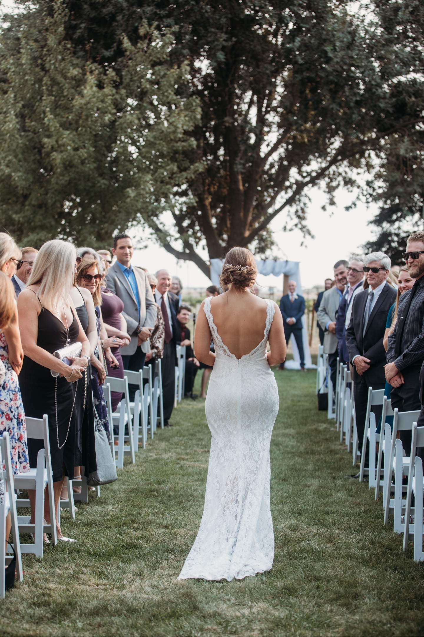 Back of the bride as she walks down the aisle. Sacramento wedding photography by Liz Koston.
