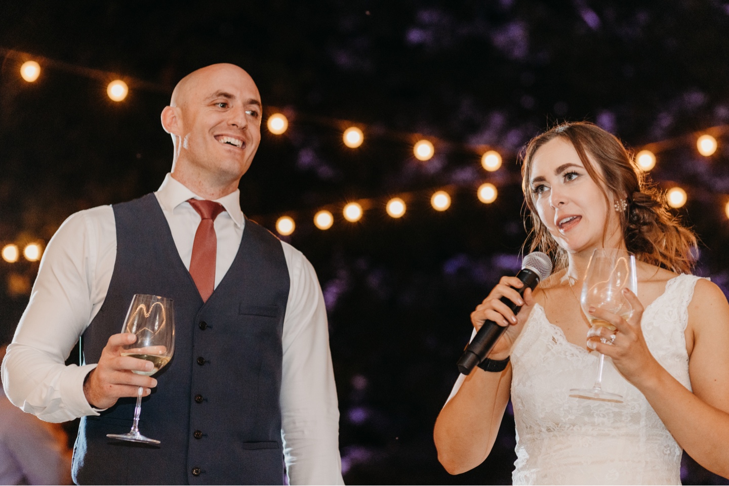 Bride gives a speech as her husband stands next to her. Wedding photography in Sacramento by Liz Koston.