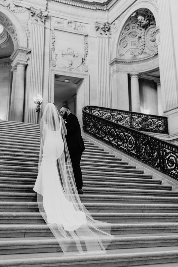 View from behind as the couple walk up the Grand Staircase in San Francisco's City Hall. Photo by Liz Koston Photography.