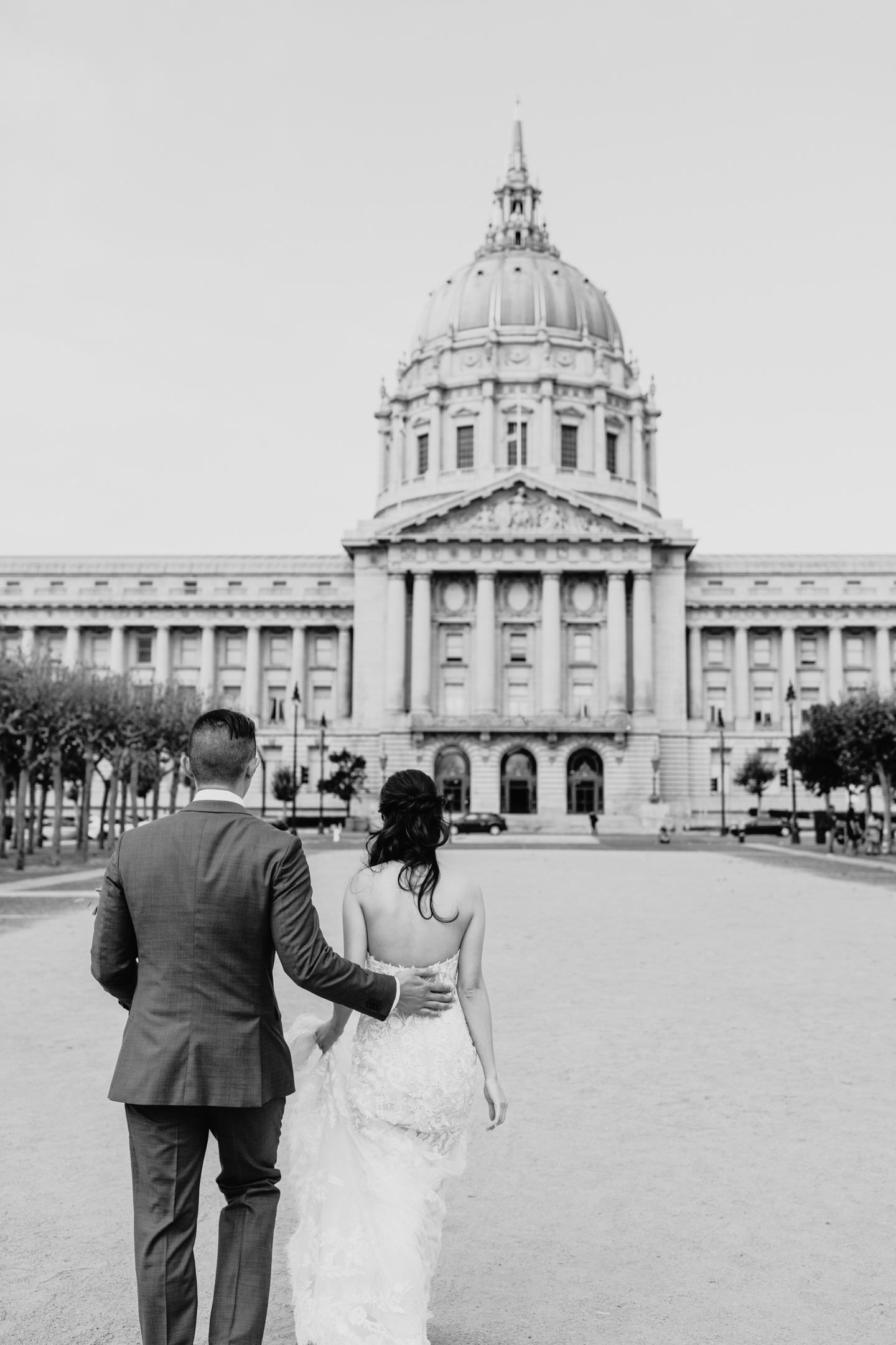 Bride and groom walk towards San Francisco City Hall for their civil ceremony.