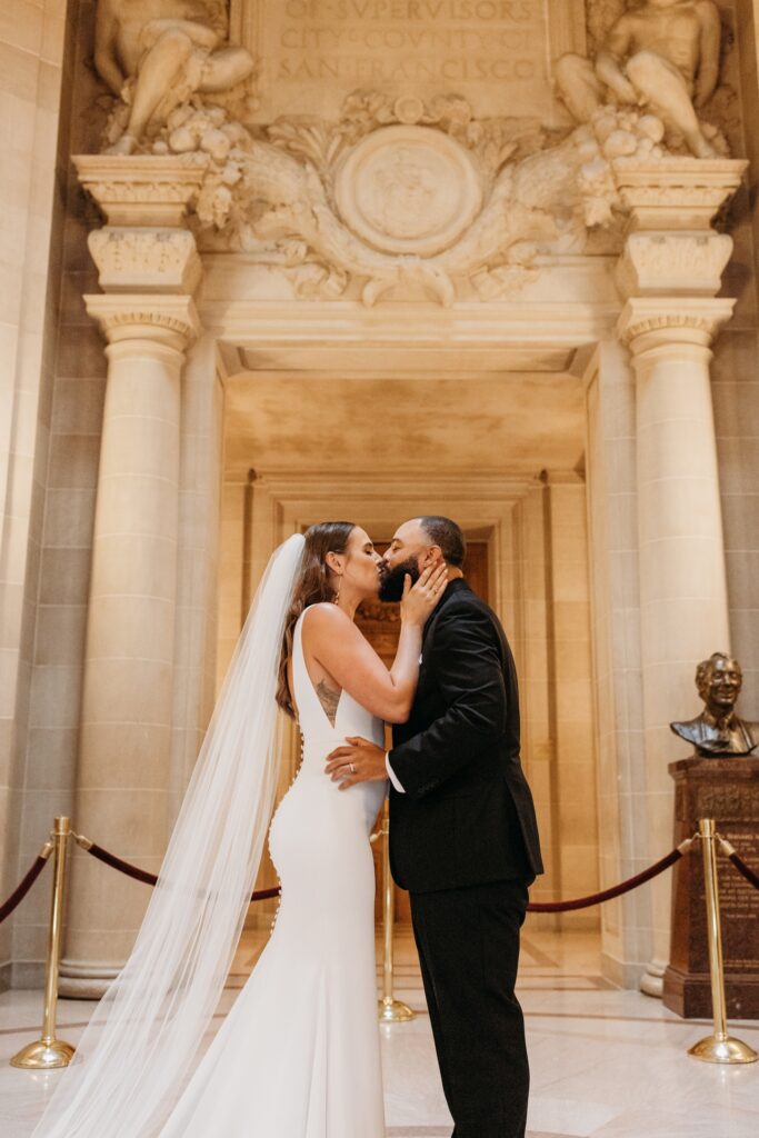 Bride and groom kiss after they get married in San Francisco City Hall. Photo by Liz Koston Photography.