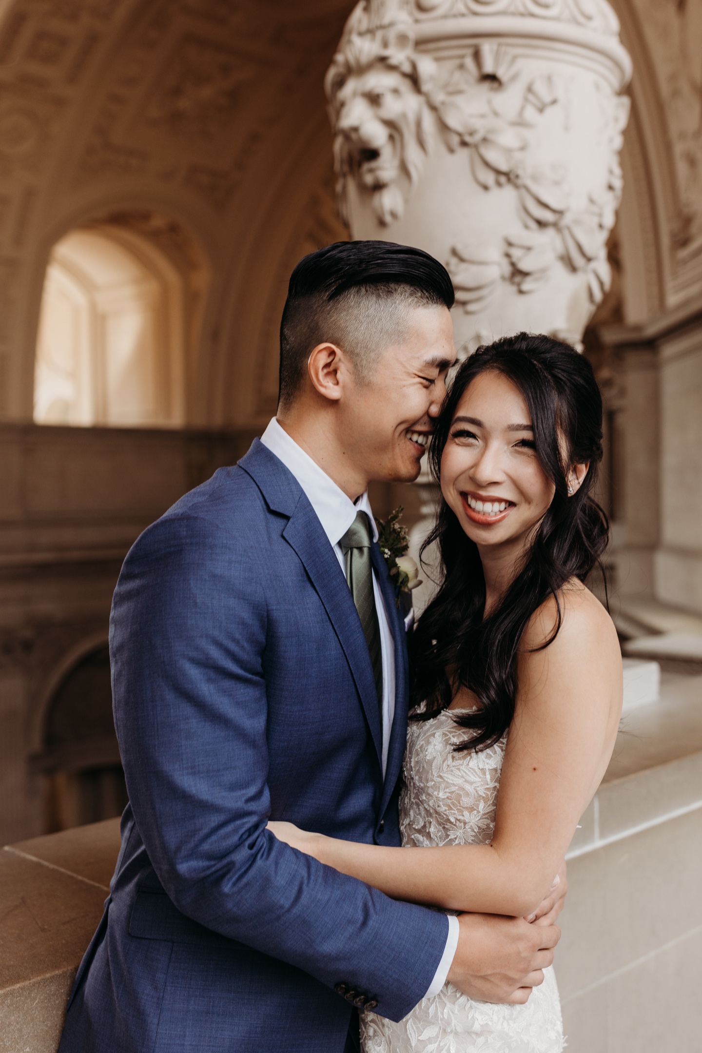 Bride and groom hug and smile big after their San Francisco City Hall wedding.