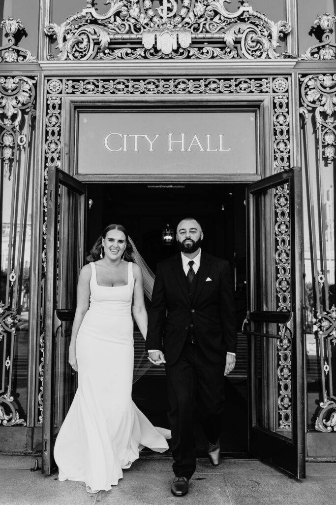 Bride and groom exiting San Francisco City Hall after their wedding. Photo by Liz Koston Photography.