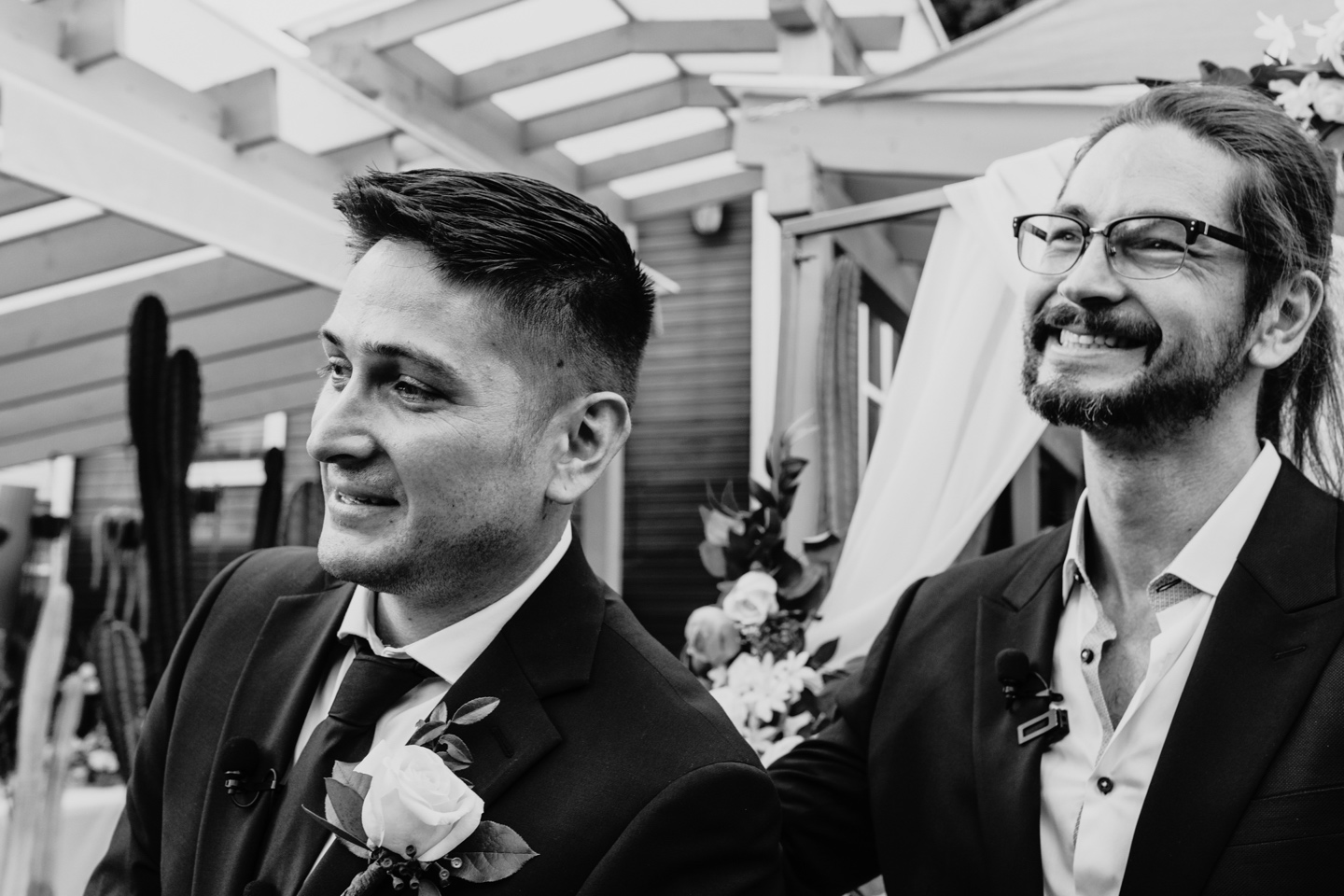 Officiant and groom smile as they watch the bride walk down the aisle.