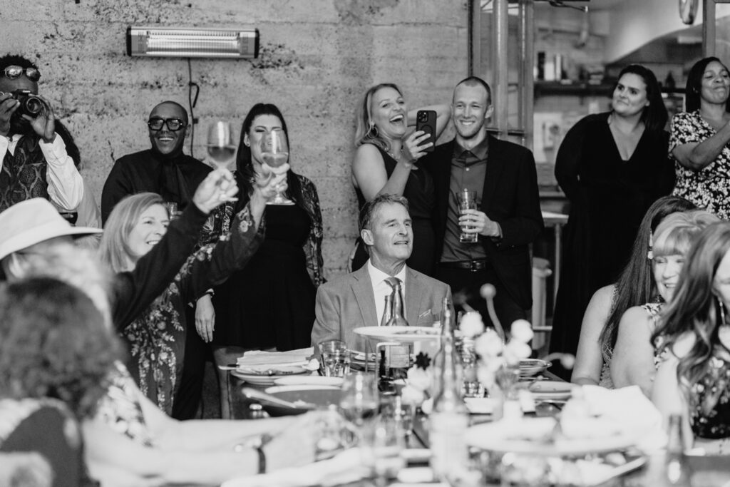 Wedding guests toast bride and groom at a San Francisco wedding reception. Photo by Liz Koston Photography.