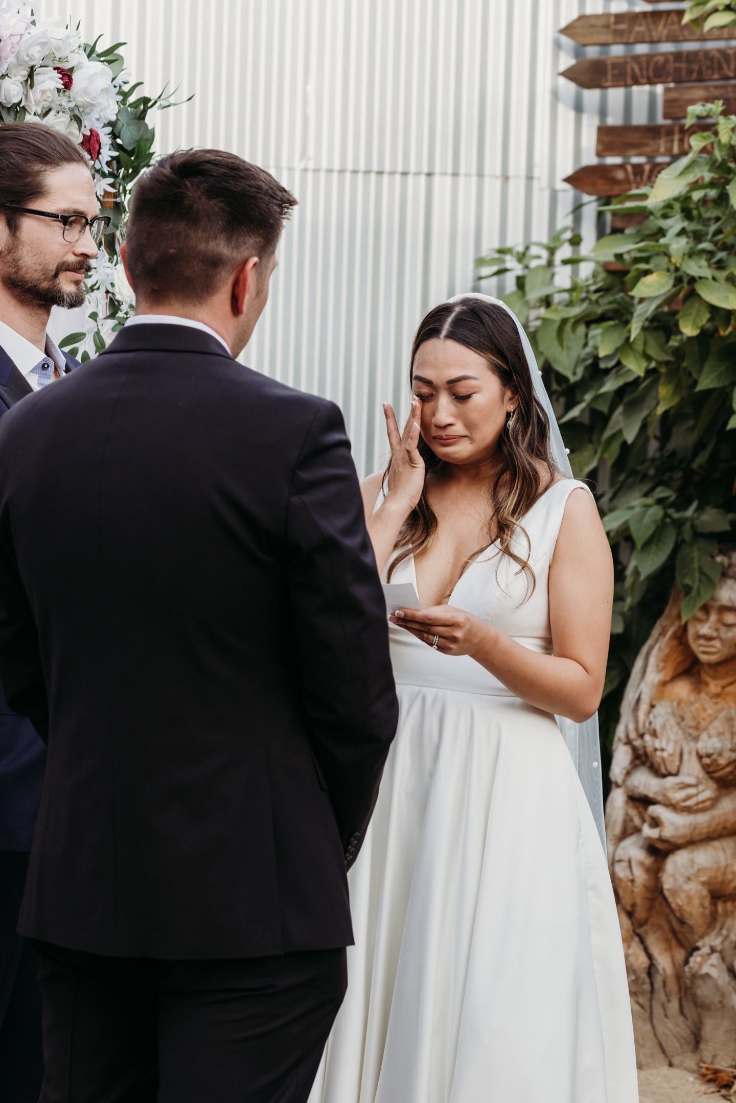 Bride wipes away a tear as she reads her wedding vows to her husband. Liz Koston Photography.