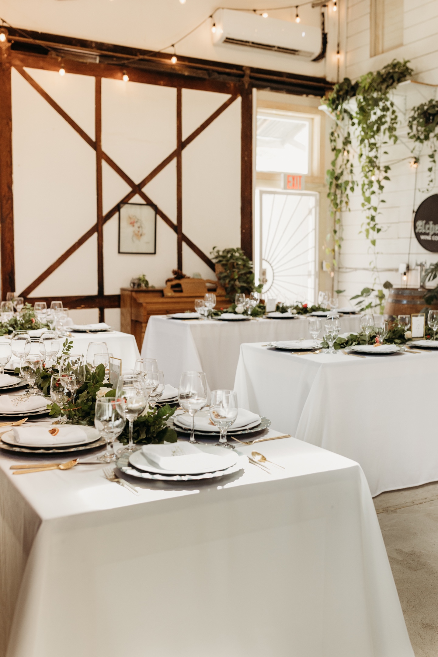 Table settings with white table cloths, green center pieces, and gold utensils. Liz Koston Photography.