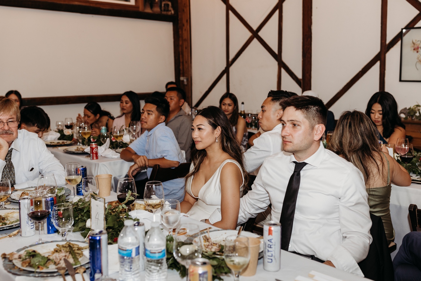 Bride and groom surrounded by guests listening to wedding speeches. Prickly Pear wedding. Liz Koston Photography.