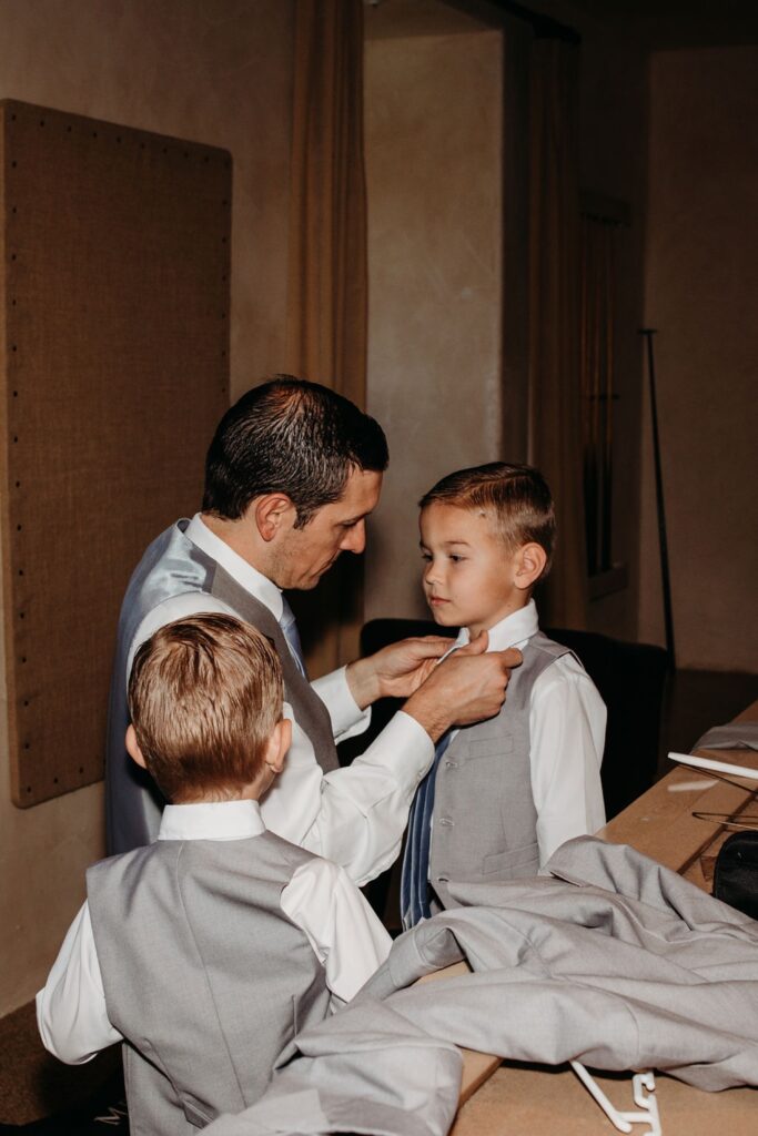 Father helping his little sons get ready for a wedding. Liz Koston Photography.